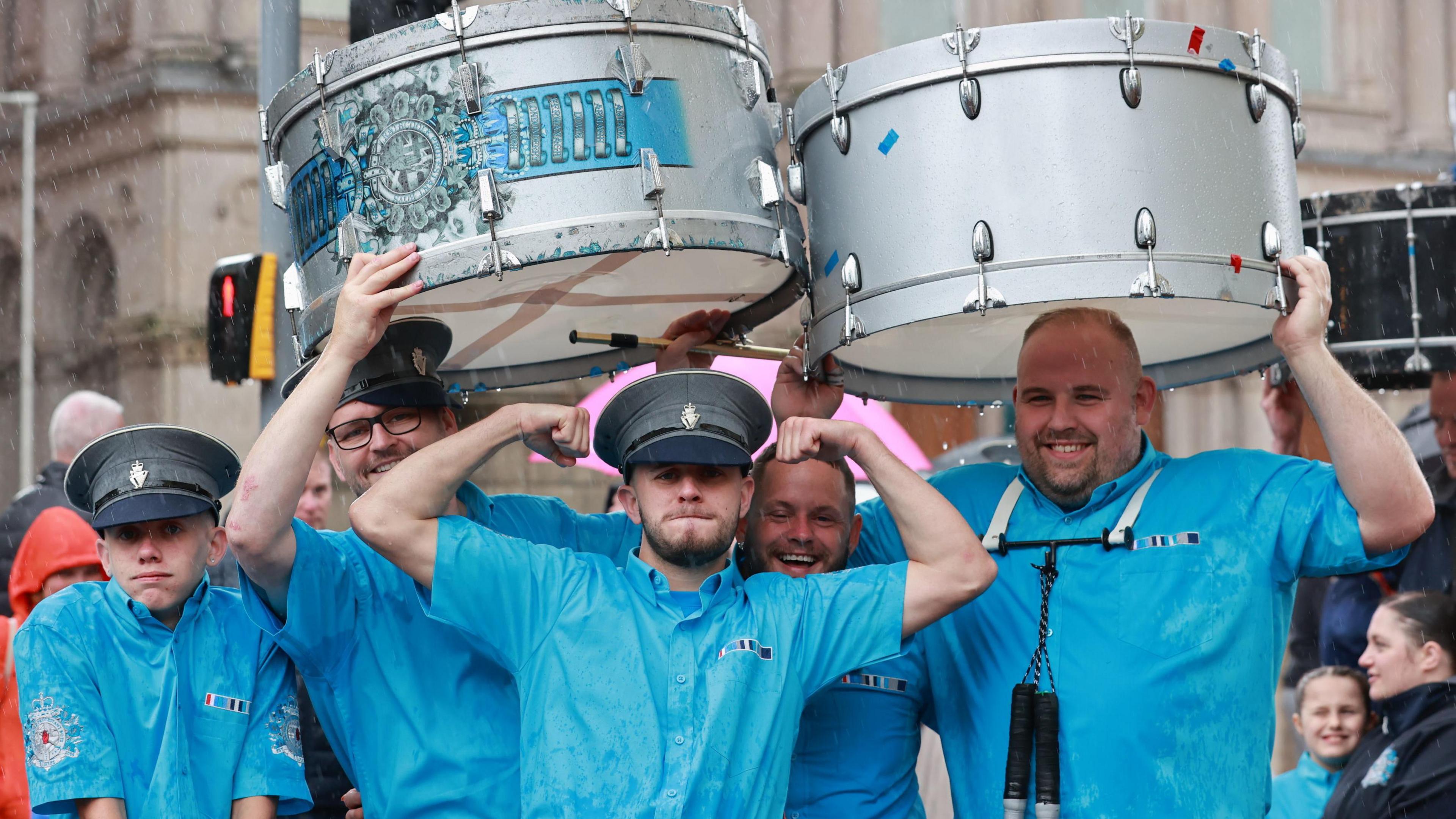 Band members at Belfast Twelfth with drum above their heads 