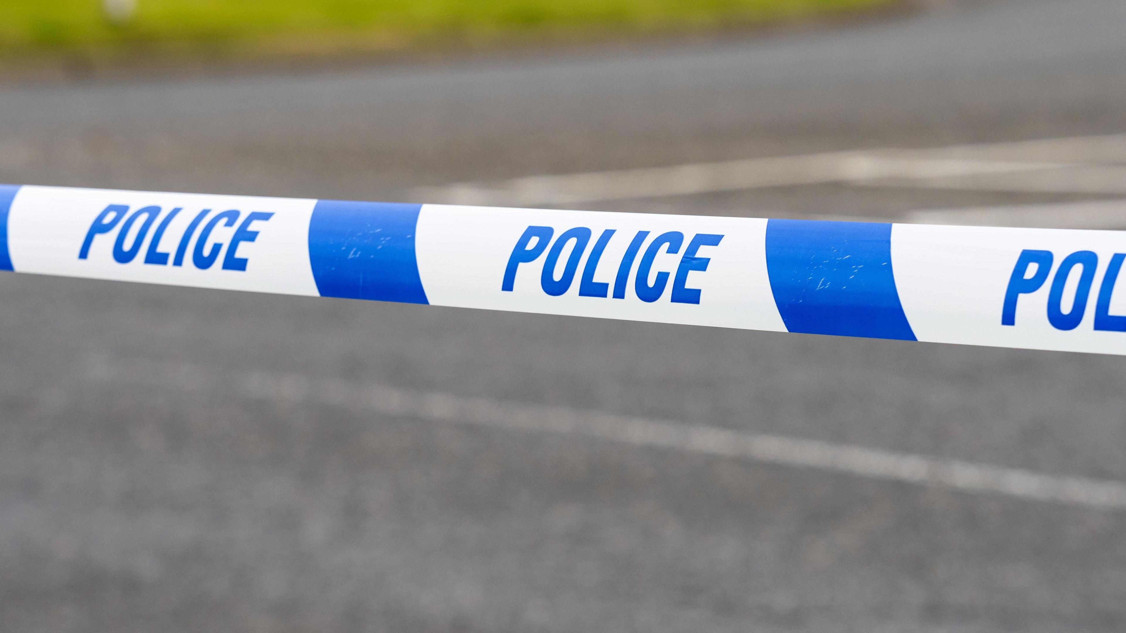 A close-up of a police tape on a road