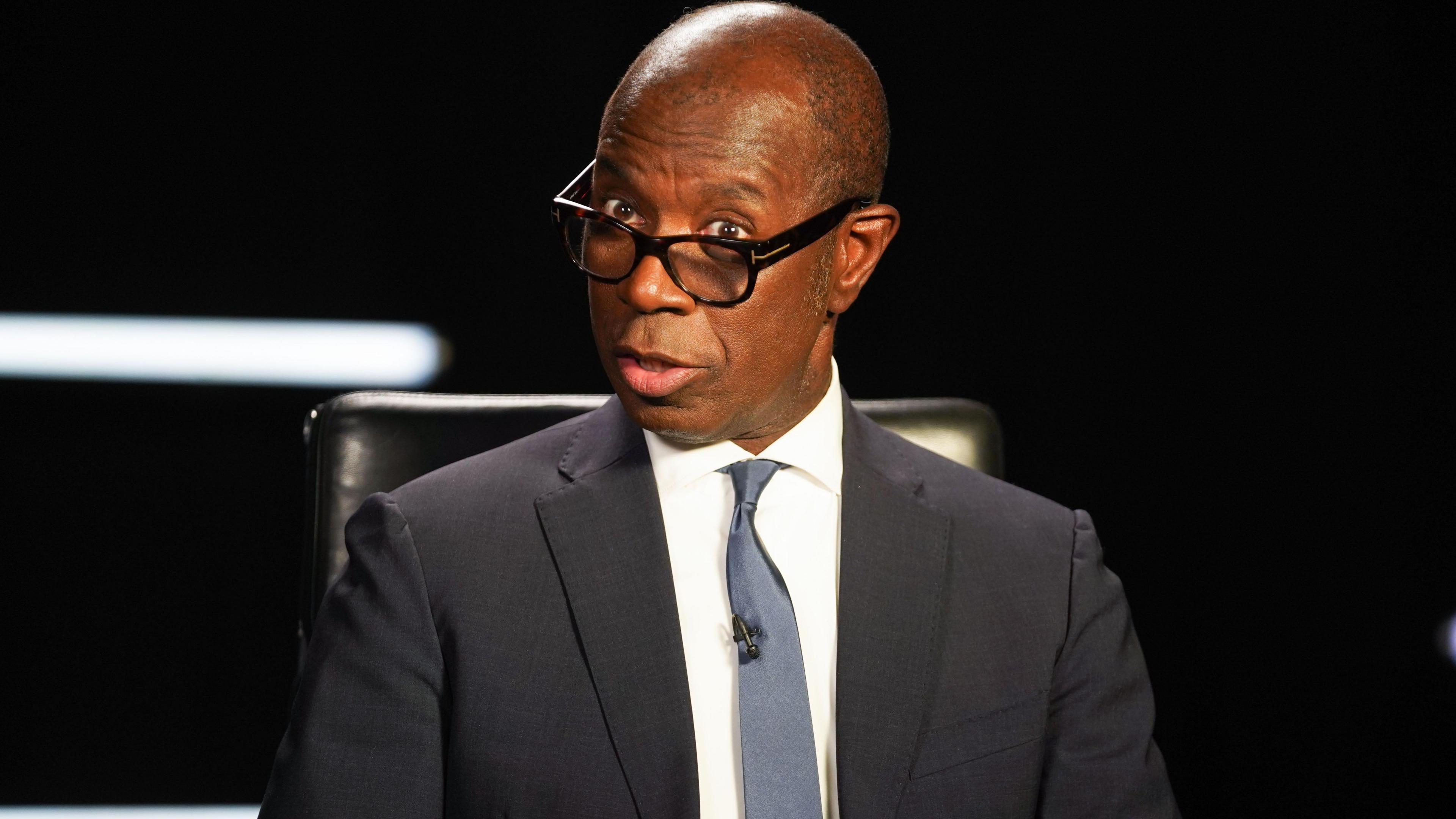 Clive Myrie presenting Mastermind, wearing a suit with a blue tie