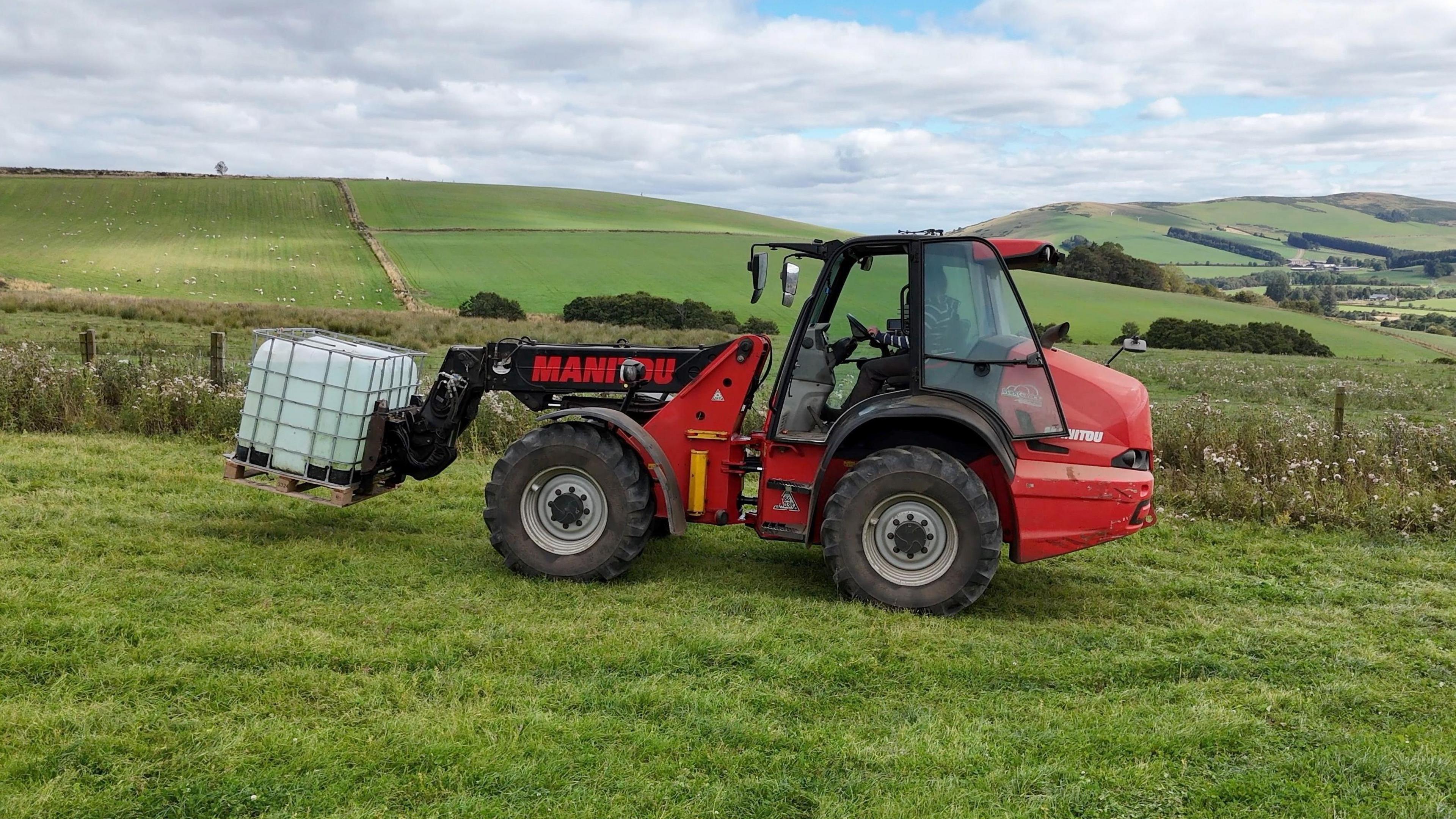 A loader carries the water to another field