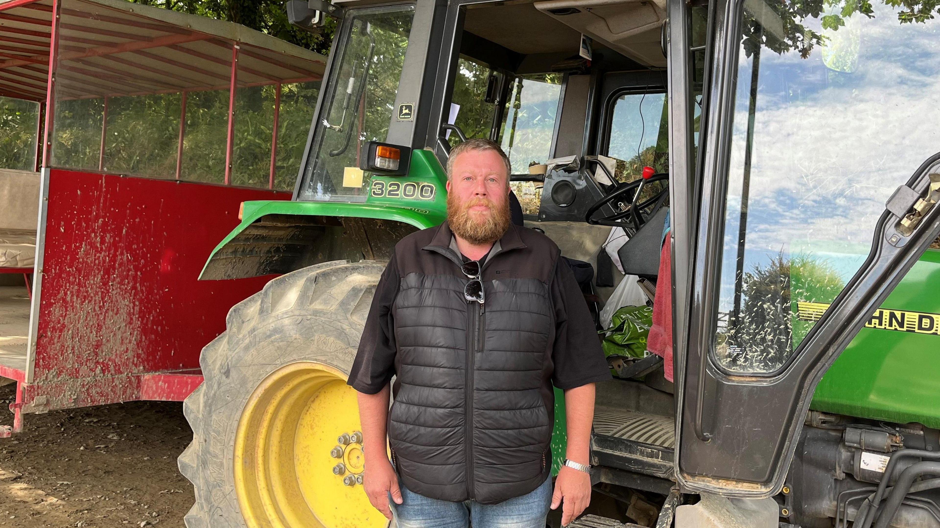 Peter Plummer beside the 'toast rack' tractor bus