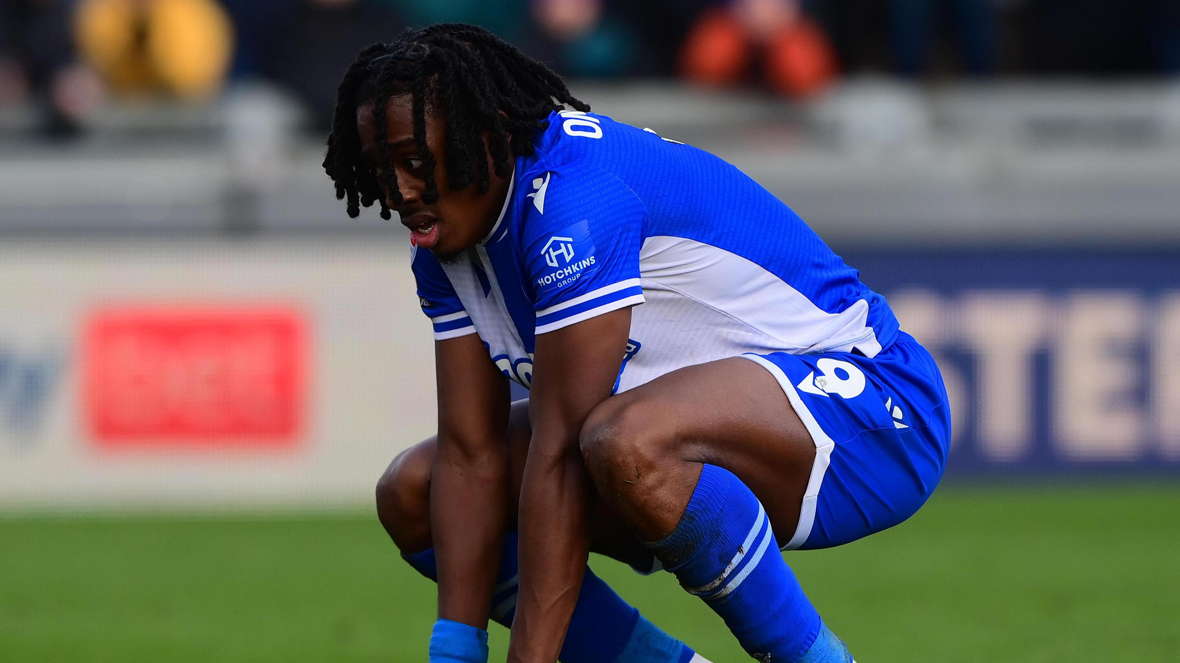 Bristol Rovers striker Promise Omochere on his haunches