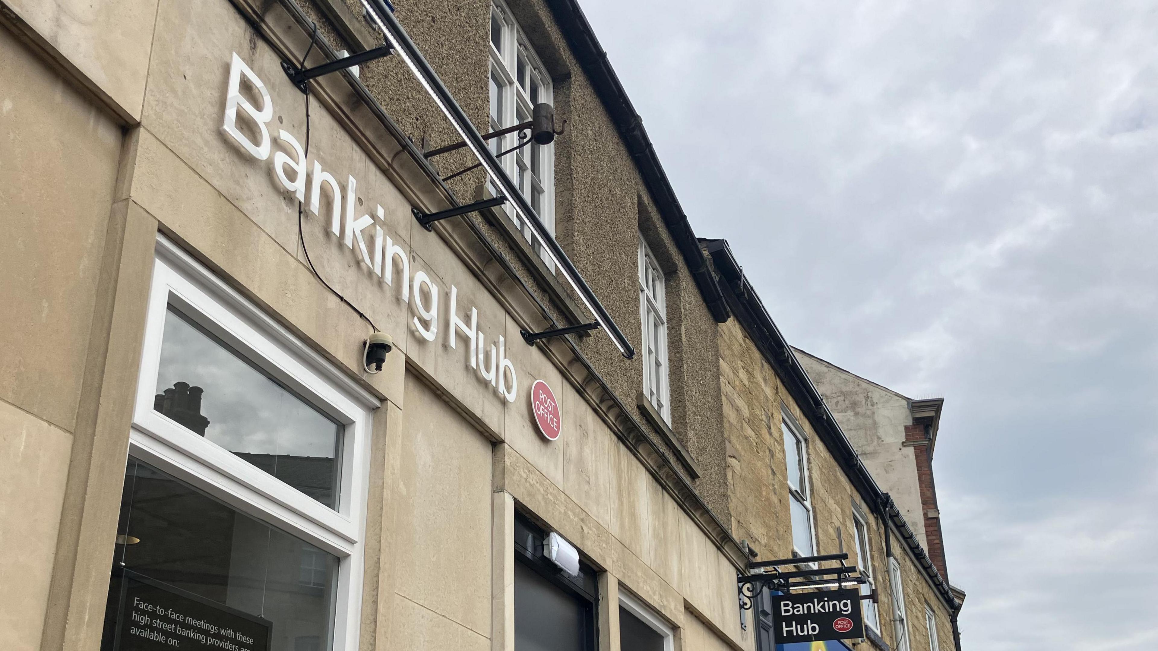 A stone building with white lettering saying 'Banking Hub'