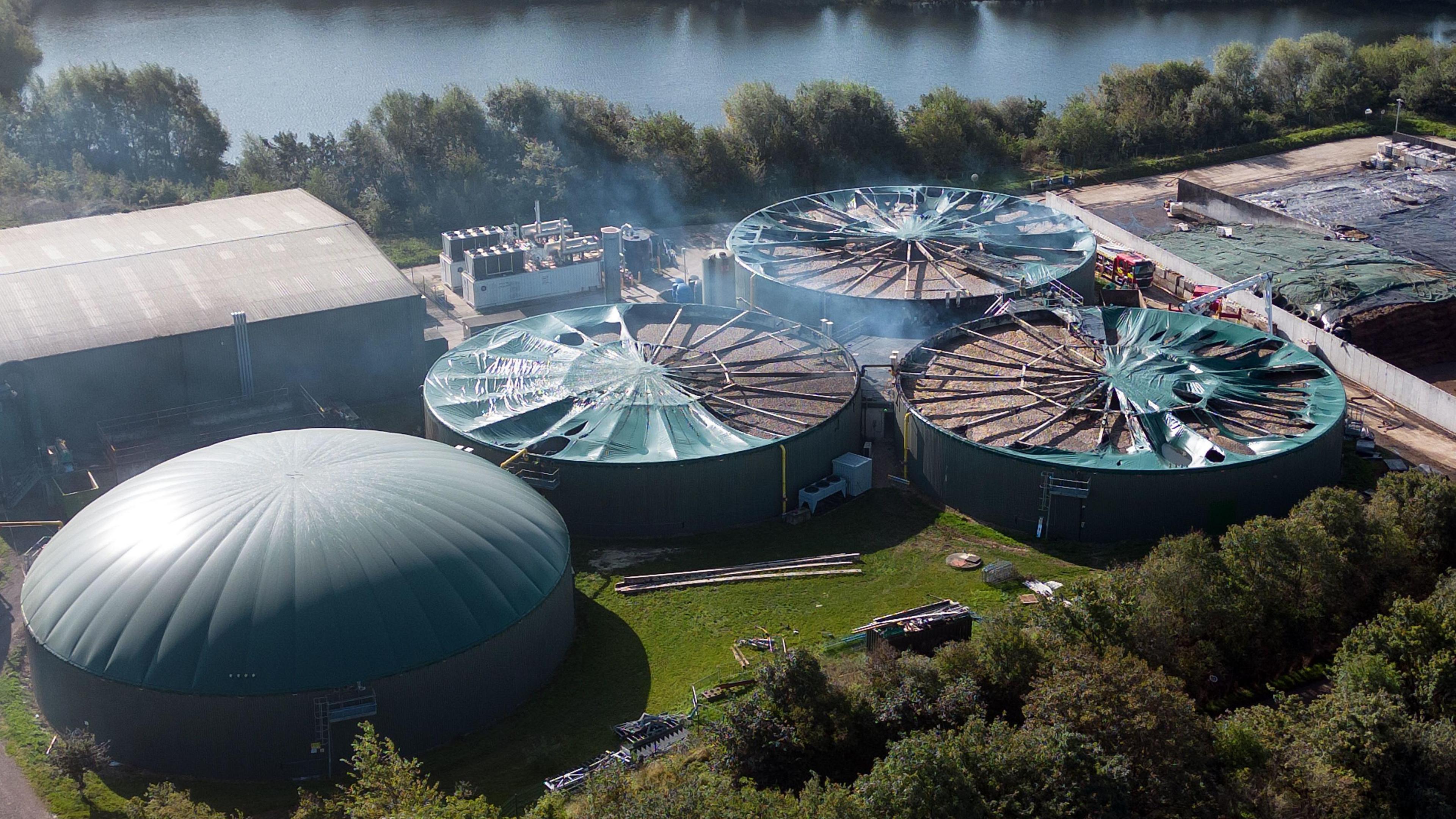 A bird eye view of the Severn Trent Green Power site in Cassington, Oxfordshire. There is smoke coming out of the tanks. It's a sunny day.