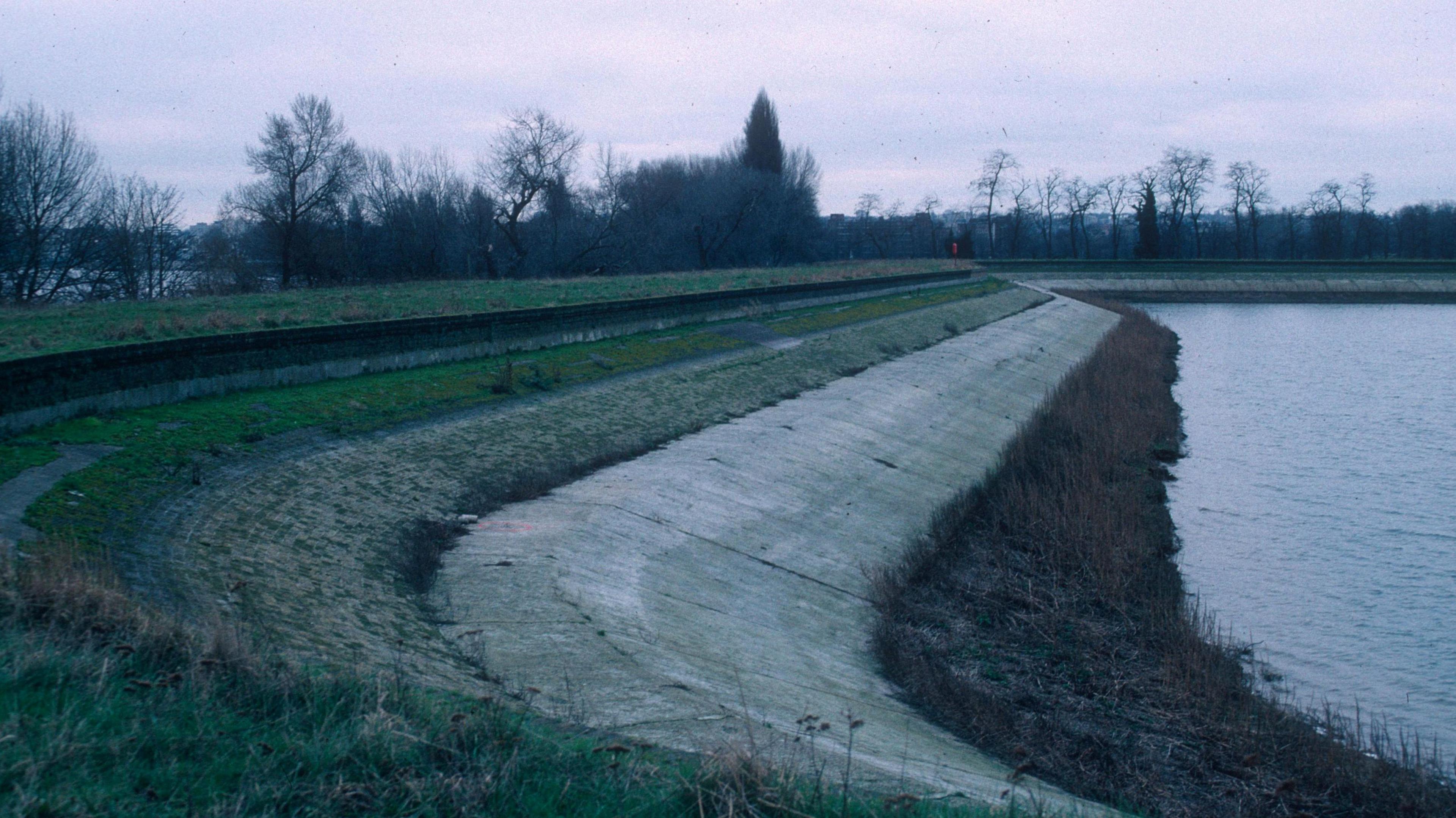 A concrete bank on the edge of a reservoir. Trees are in the background and the archive picture looks like it was taken on a winter's day.