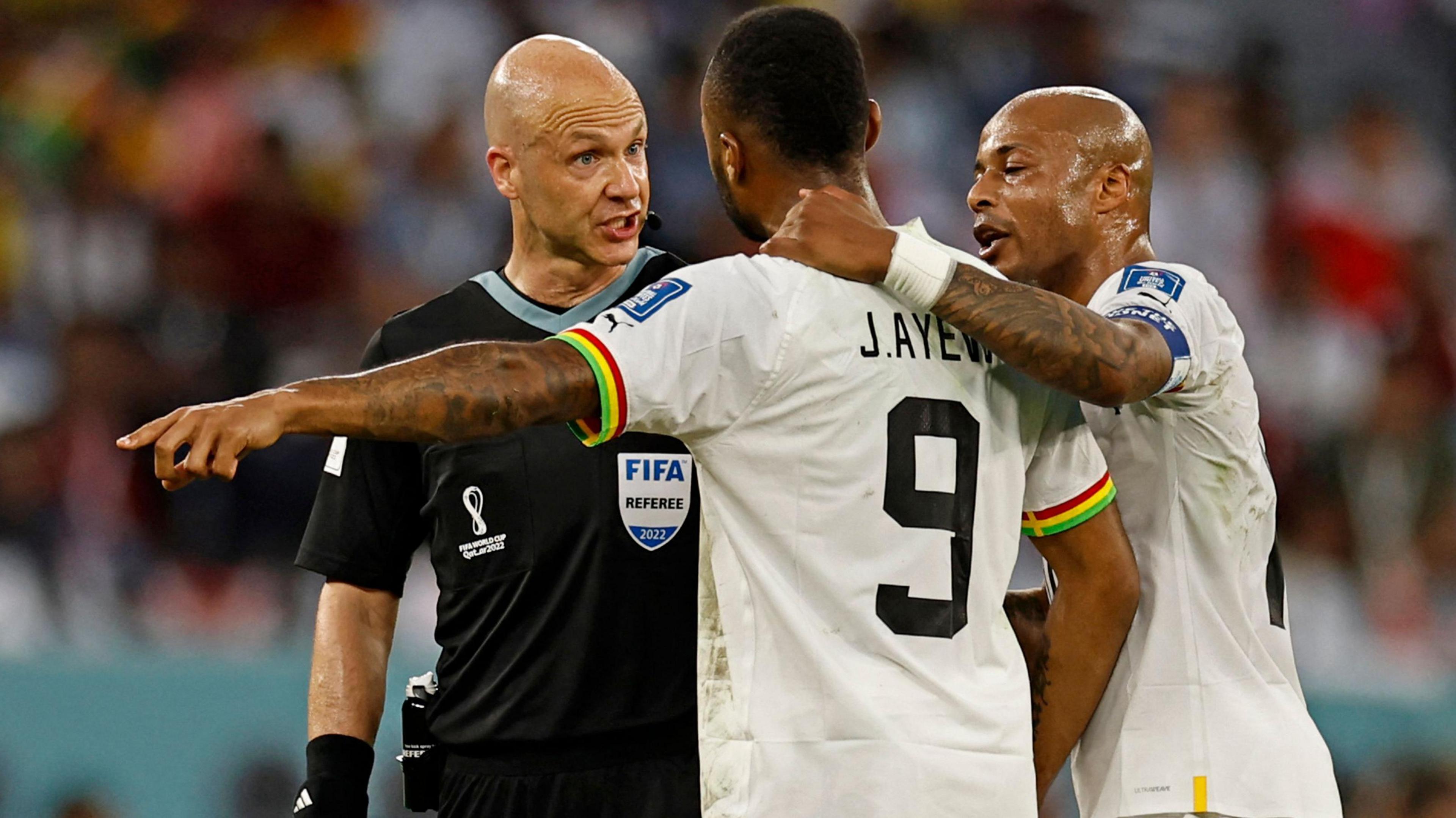 Andre Ayew comforts Jordan Ayew as the latter remonstrates with referee Howard Webb during a game at the 2022 World Cup