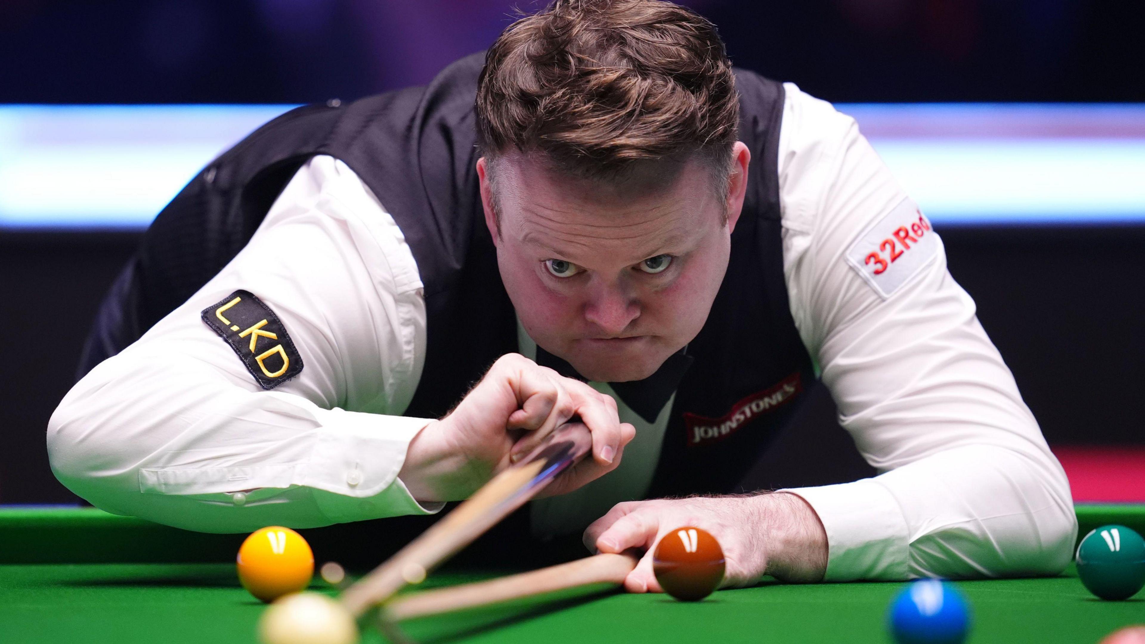 Shaun Murphy plays a shot with the rest