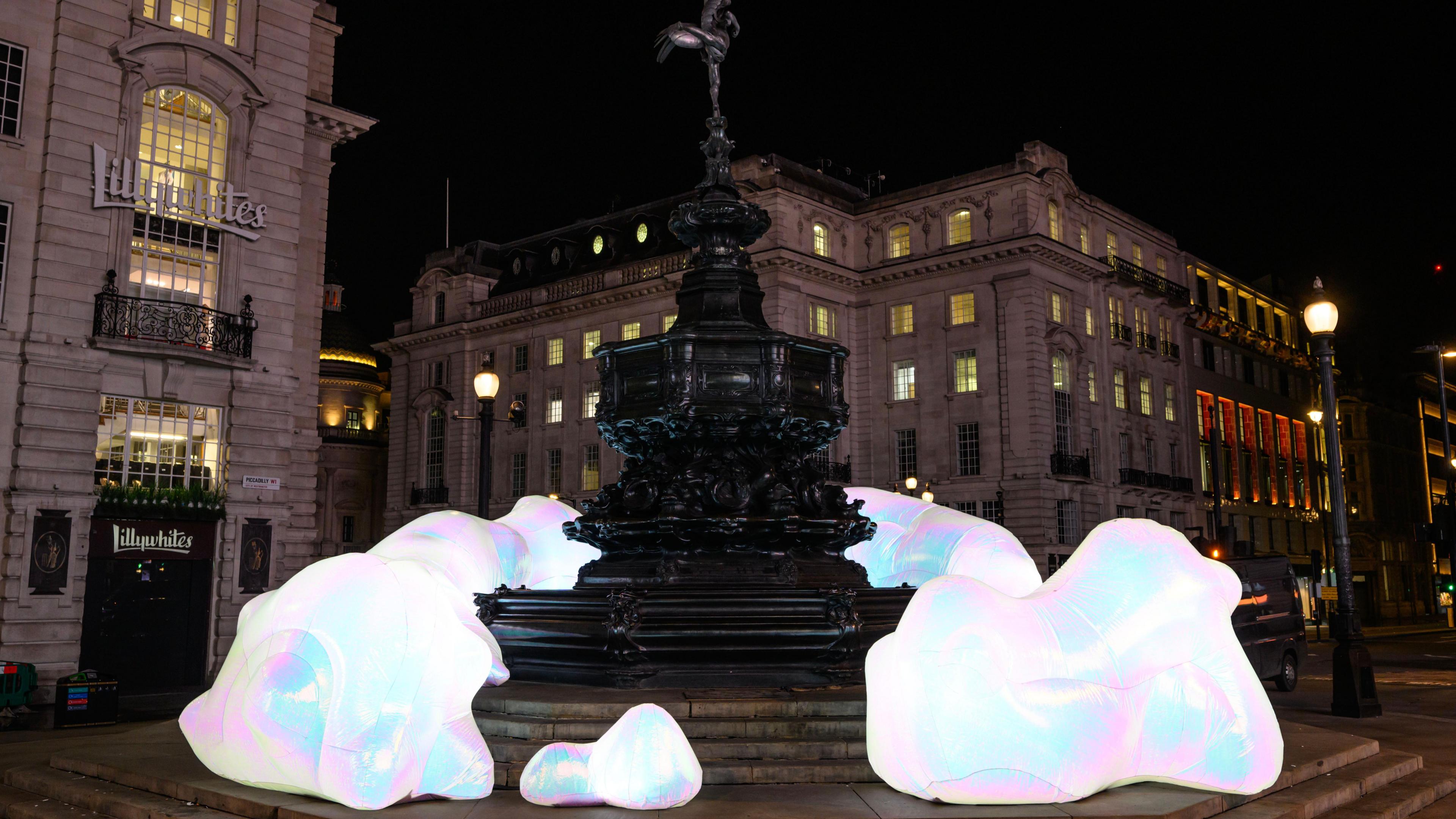 Sculptures of asteroid-shaped iridescent boulders are pictured in front of Lillywhites with other buildings in the background