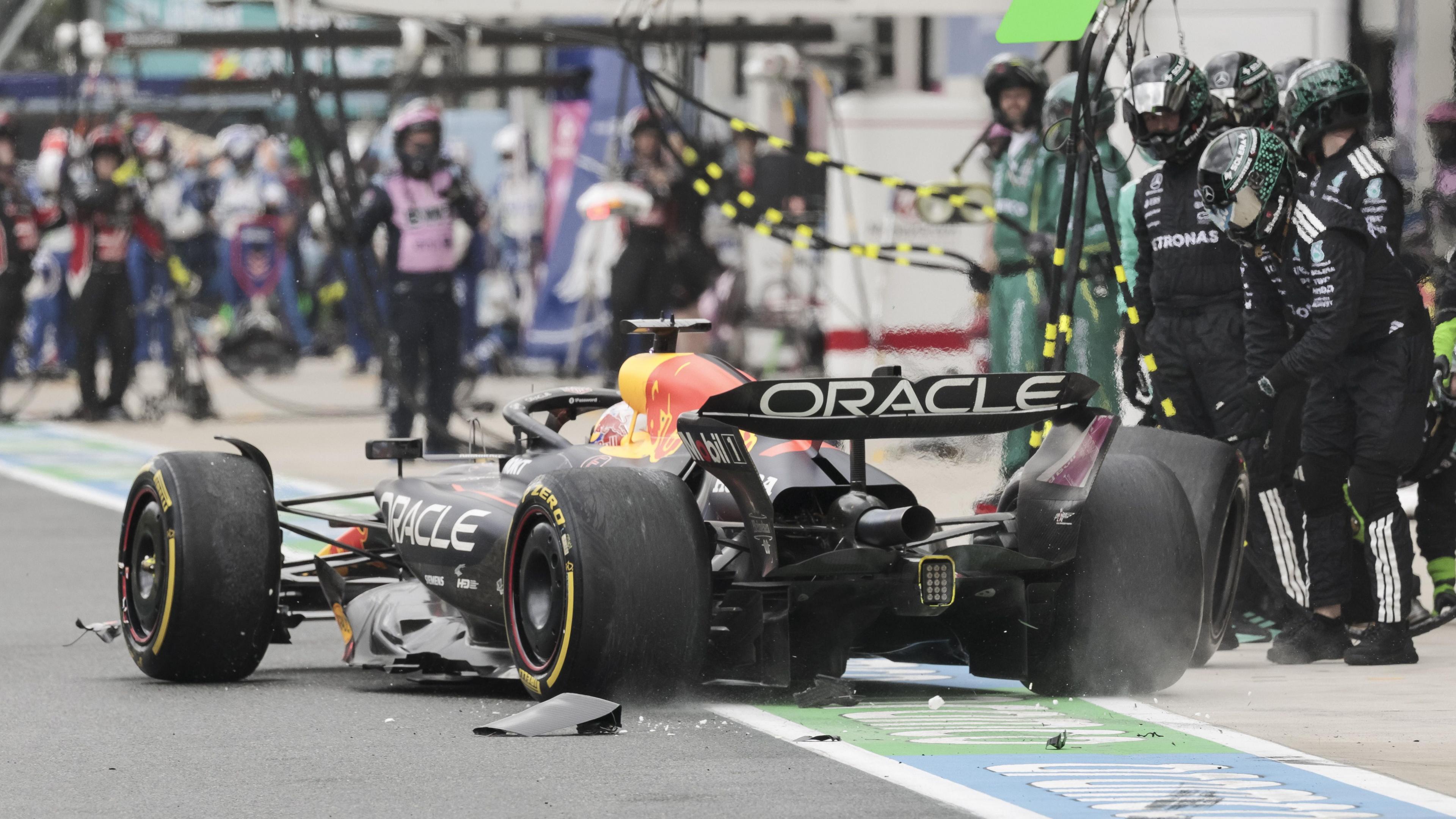Debris falls off Max Verstappen's Red Bull in the pit lane