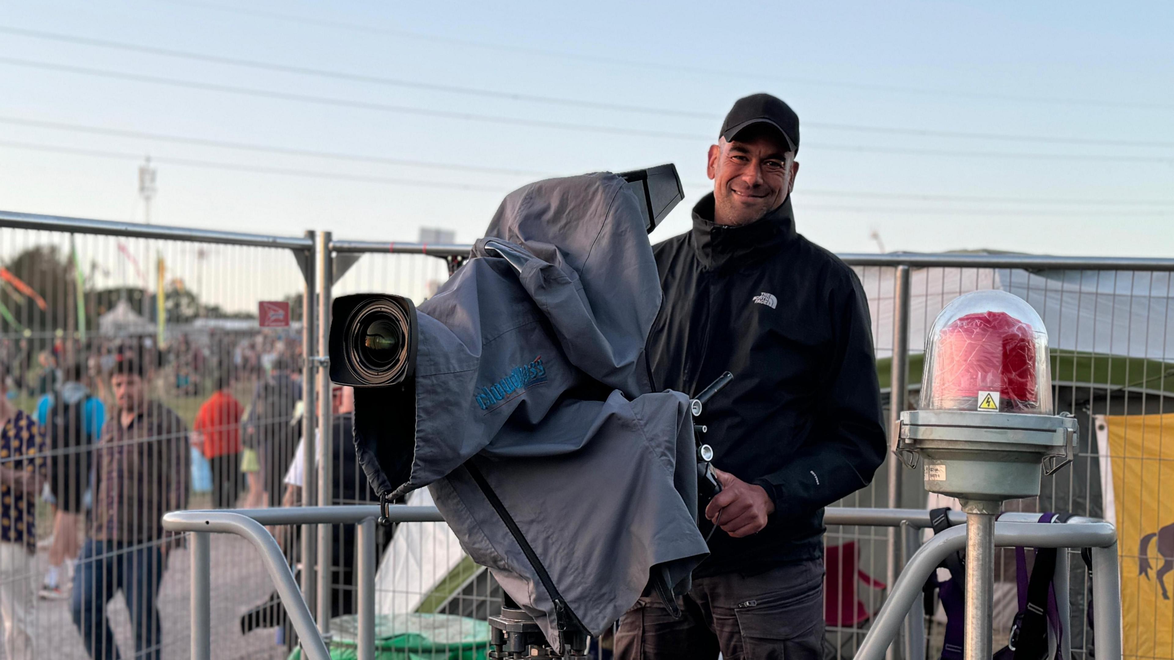 Man stood with big camera on crane platform