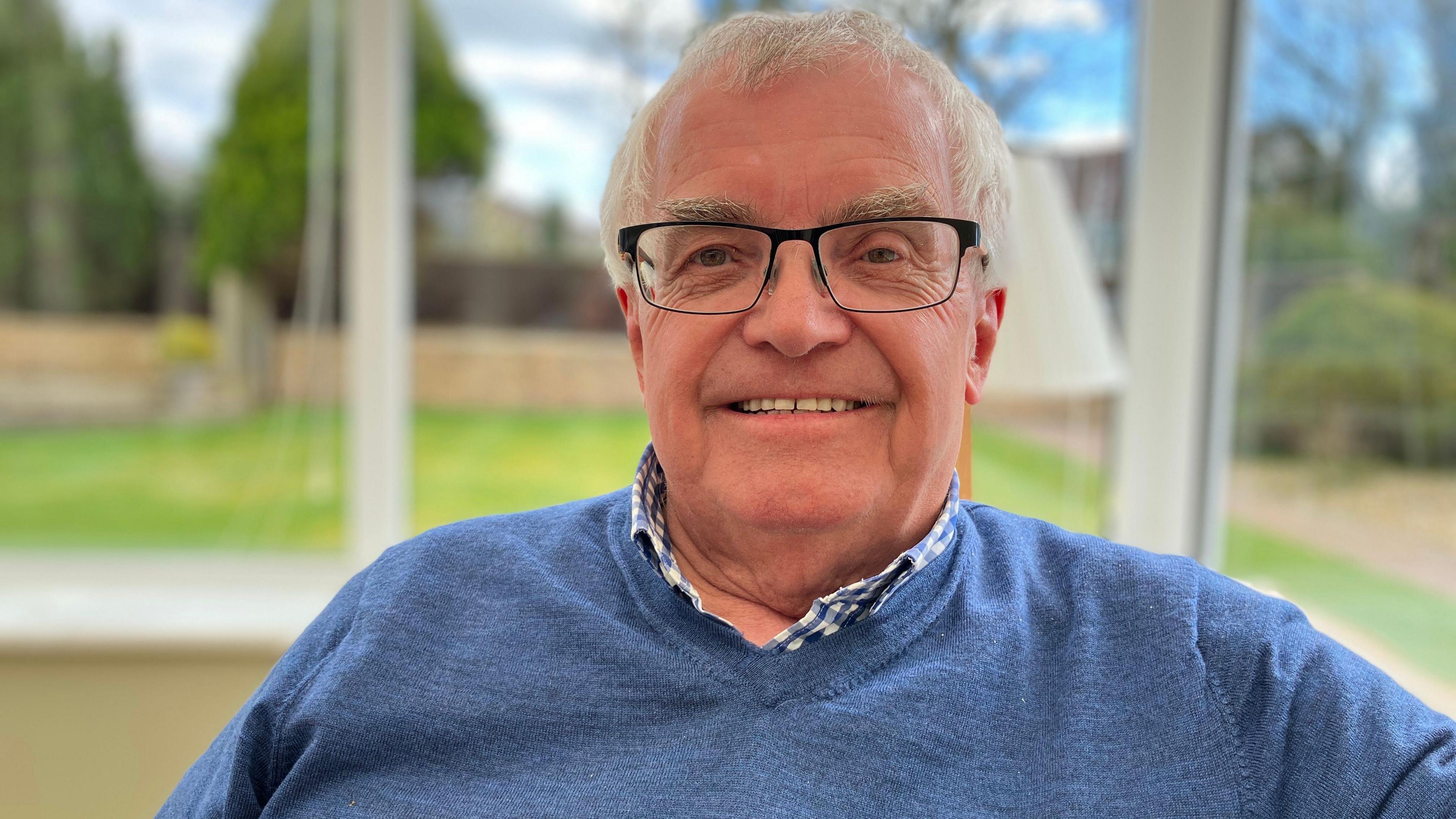 Smiling man in conservatory 