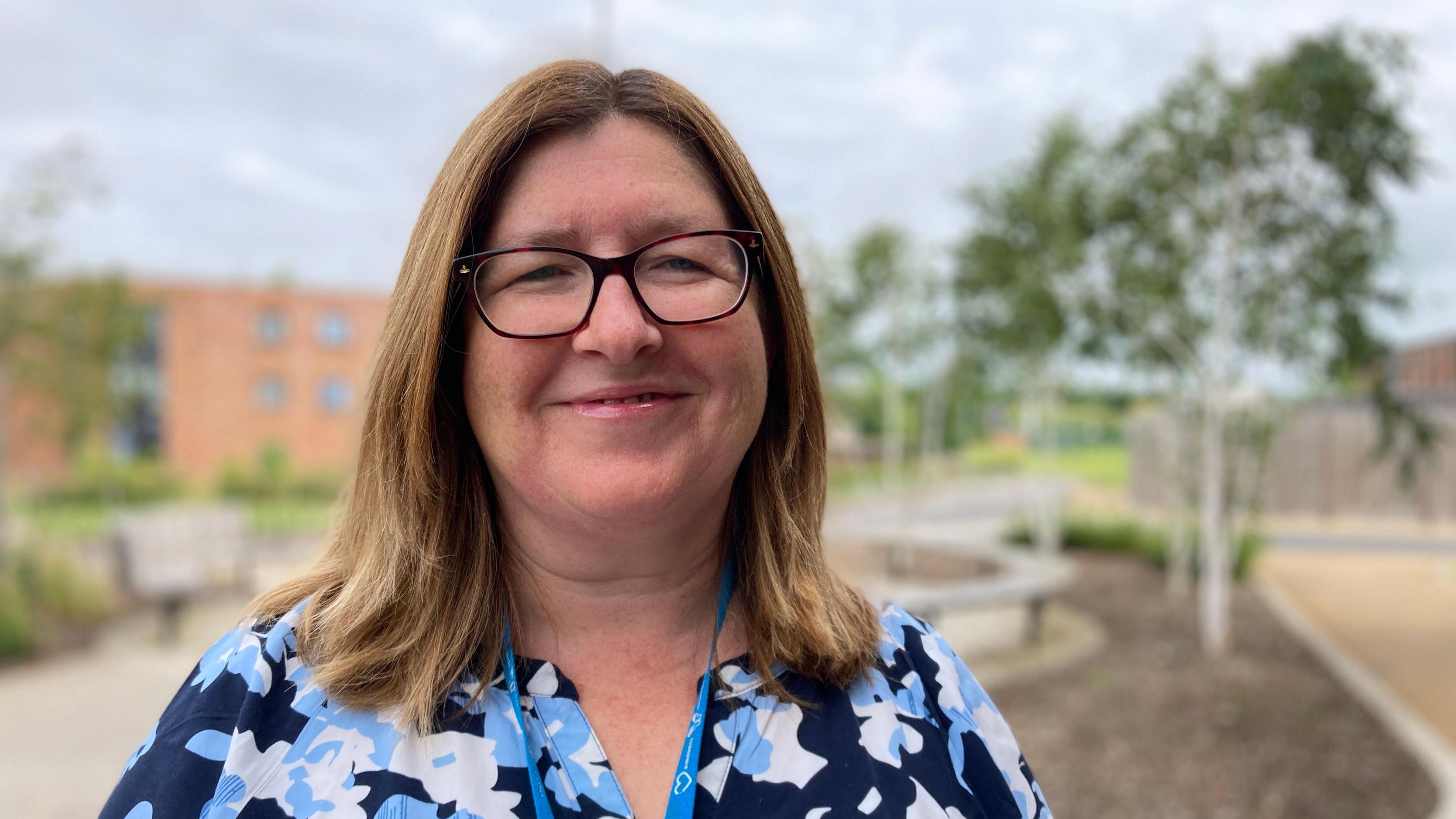 Dr Roisin Bradley in a flowery blouse looks at camera