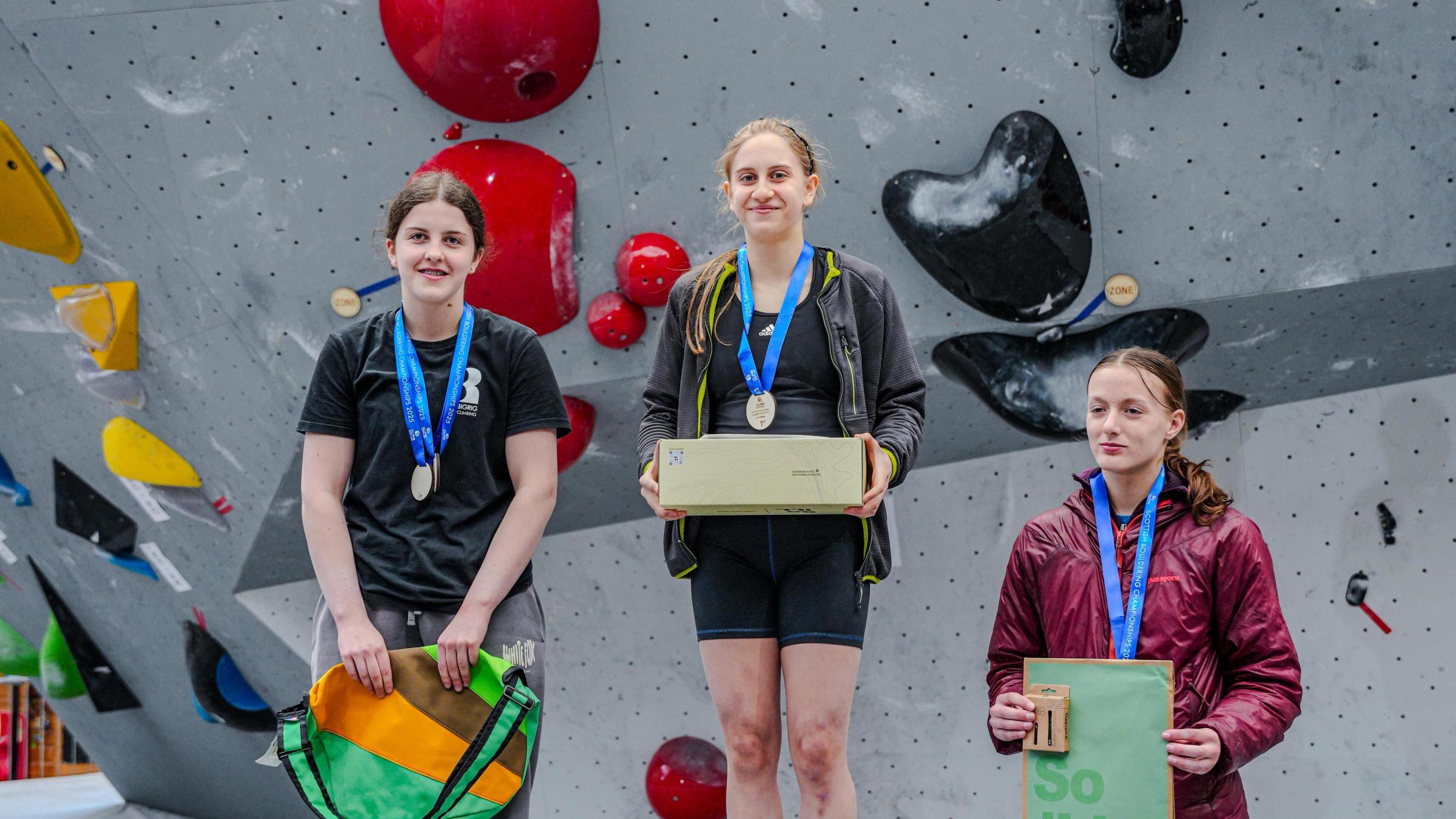 Mary Falconer with her prize on top of a climbing podium 
