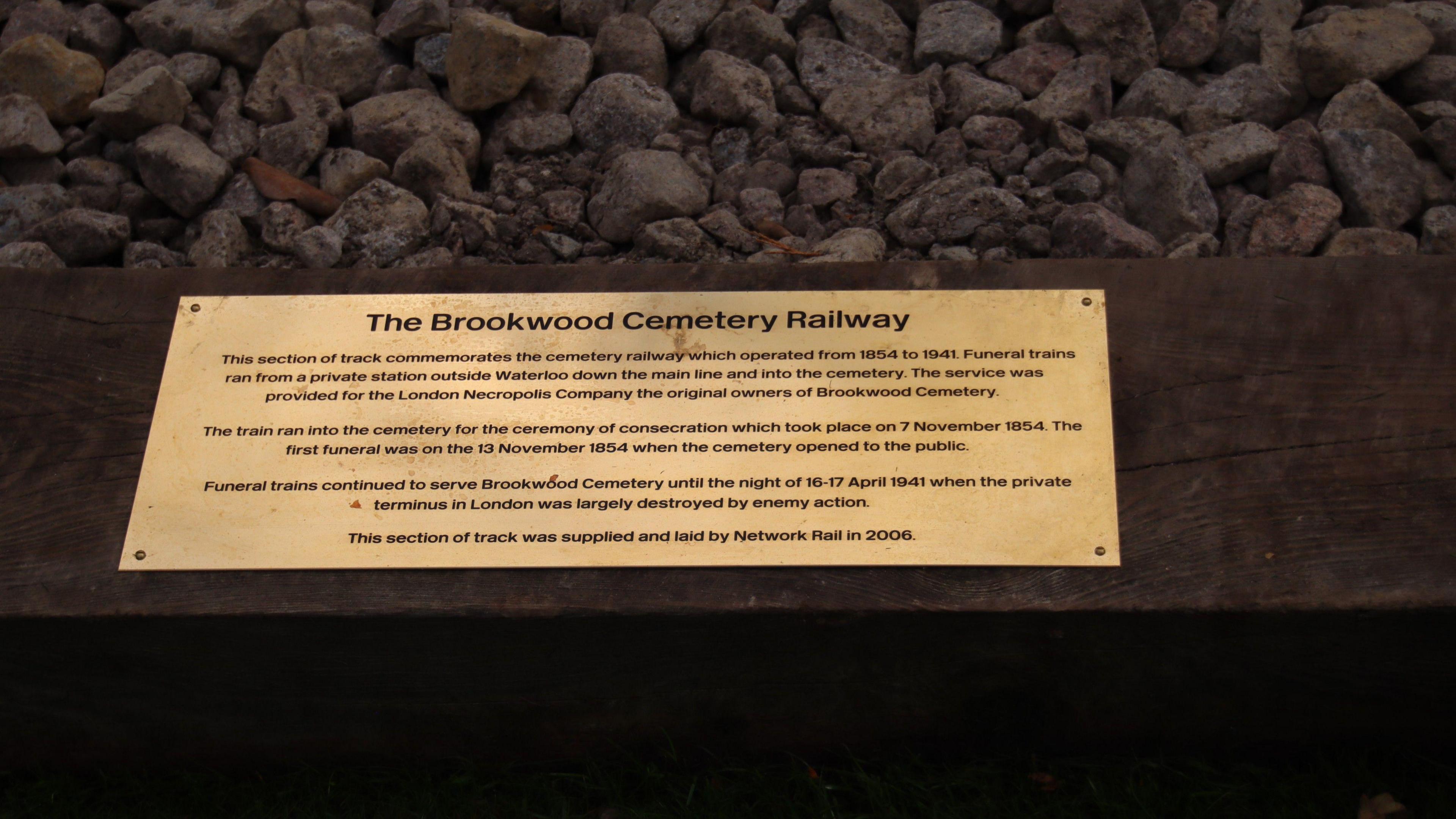 A close up of the brass memorial plaque, which explains that the memorial is to former railway workers buried at the cemetery.