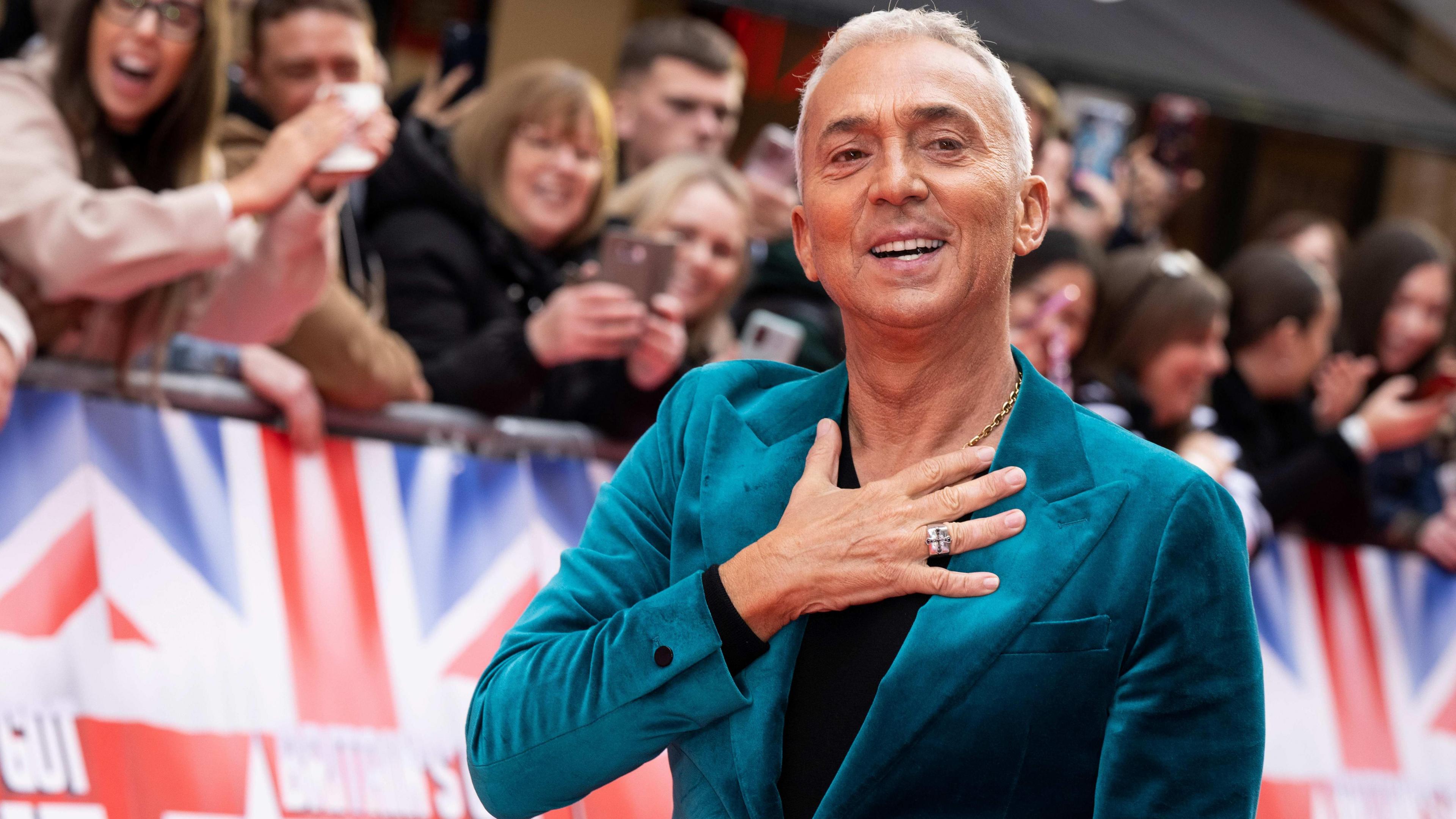 Bruno Tonioli wearing a teal velvet jacket with Britain's Got Talent fans in the background (2023)