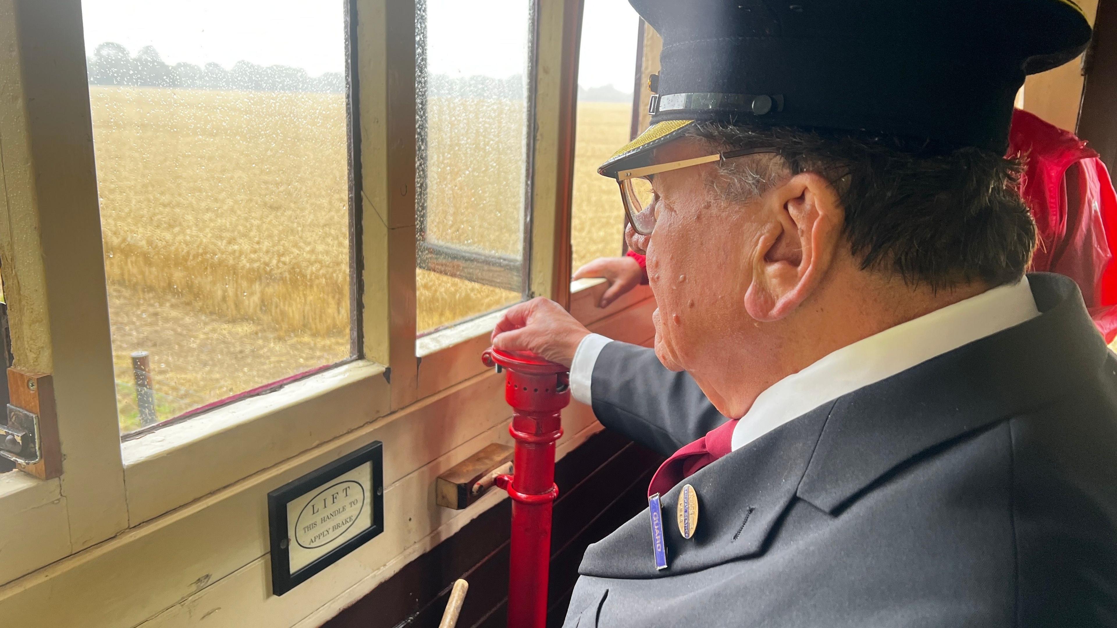A volunteer sits in a room that overlooks the railway line and operators track systems.