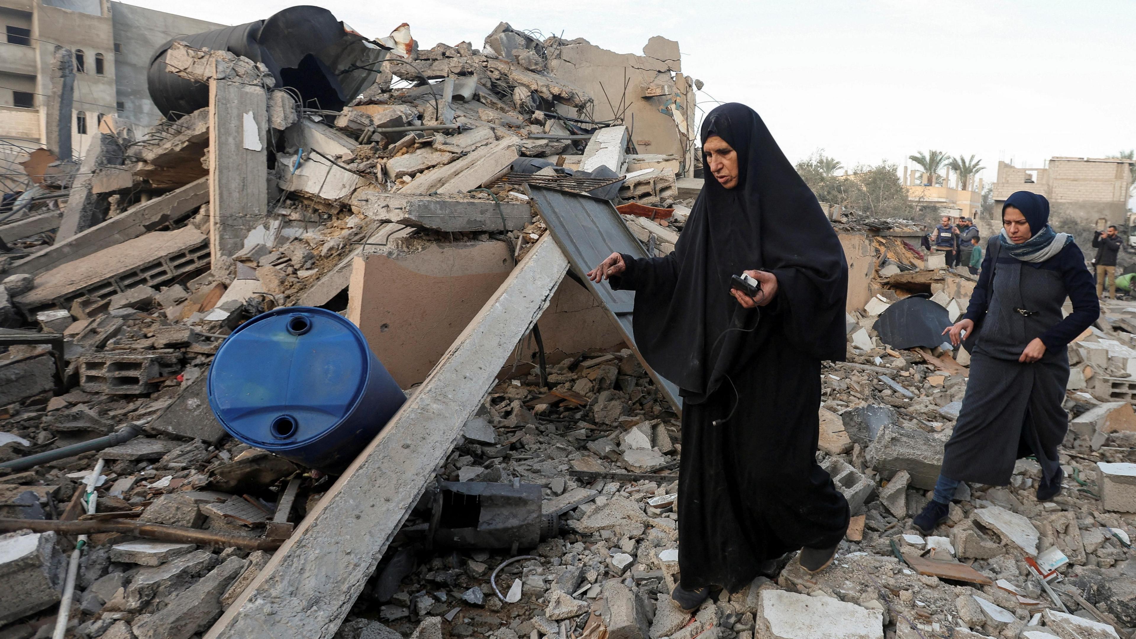 Palestinians inspect the site of an Israeli strike on a house in Deir al-Balah, central Gaza (15 January 2025)