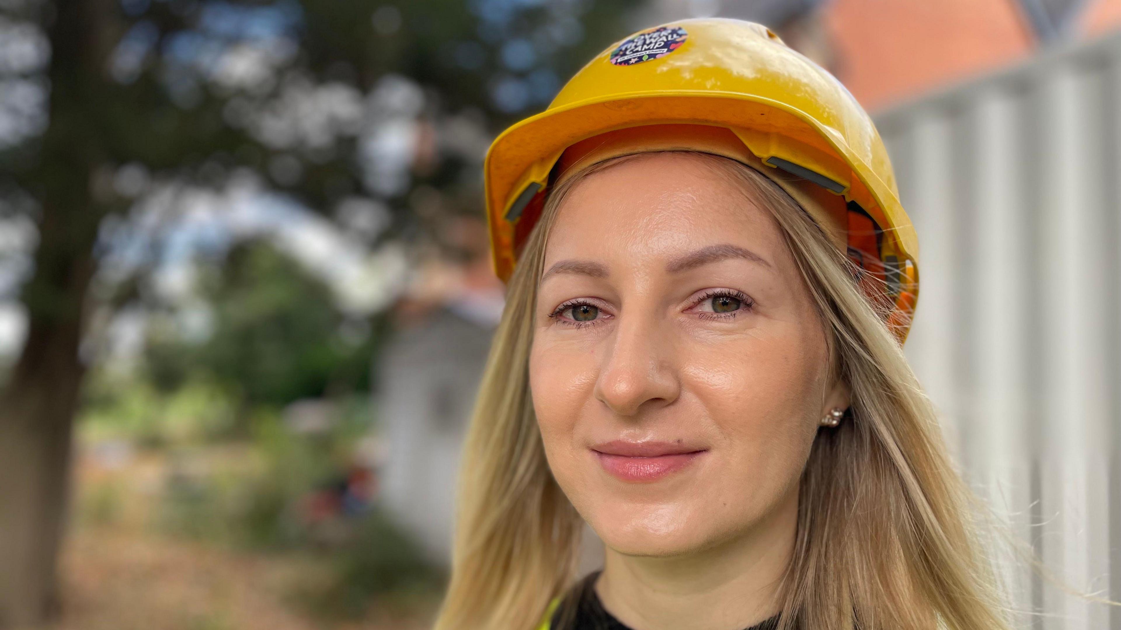 Woman with long hair and a yellow safety helmet
