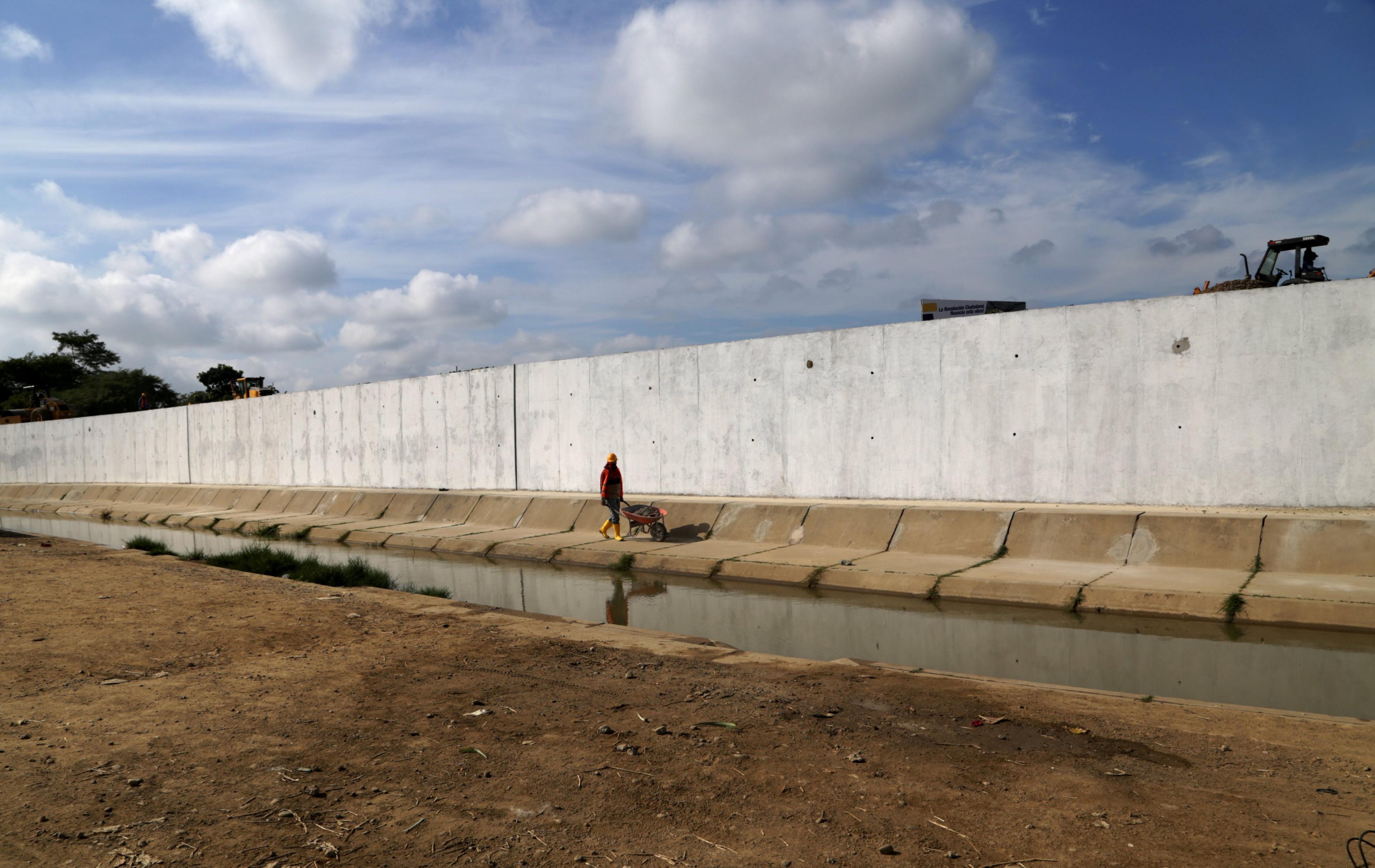 Ecuadorean workers build a new wall along the border between Peru and Ecuador