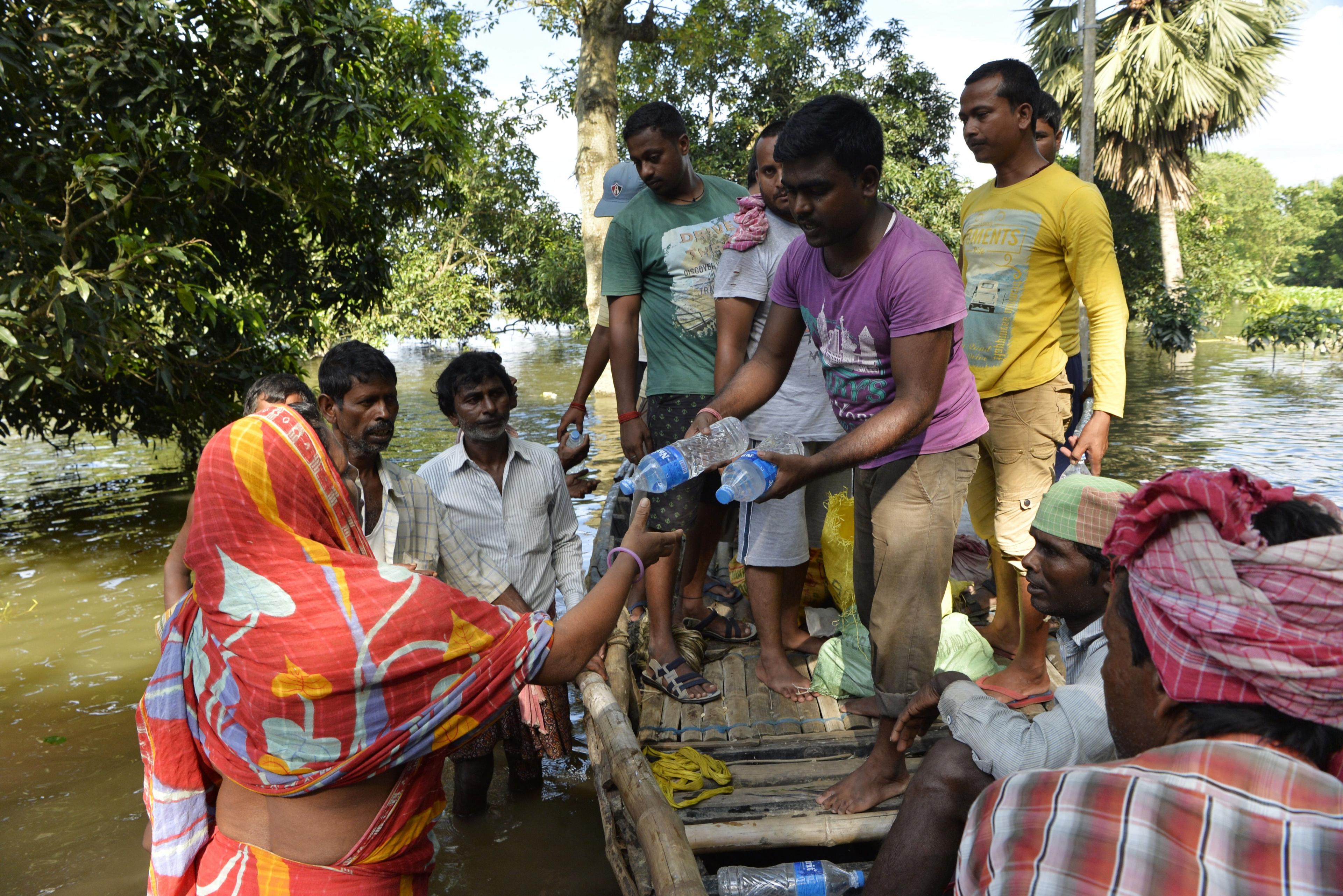 Indian flood effected villagers collect drinking water and relief food at Alal village in Malda district in the Indian state of West Bengal on August 23, 2017. More than 750 people have died in floods across South Asia, officials said August 21.