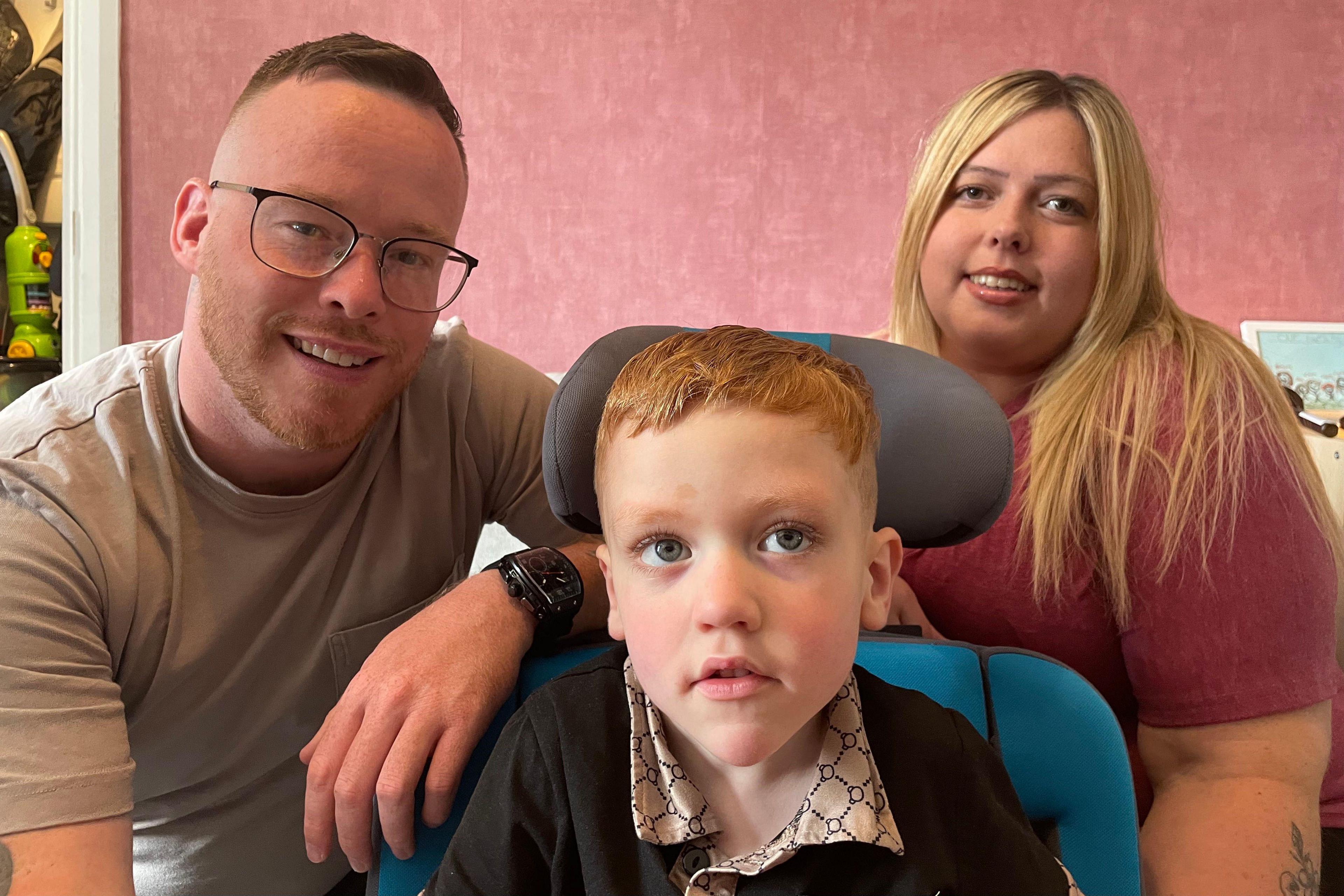 Image of dad Kelham, Harrison in his wheelchair and stepmum Shannon