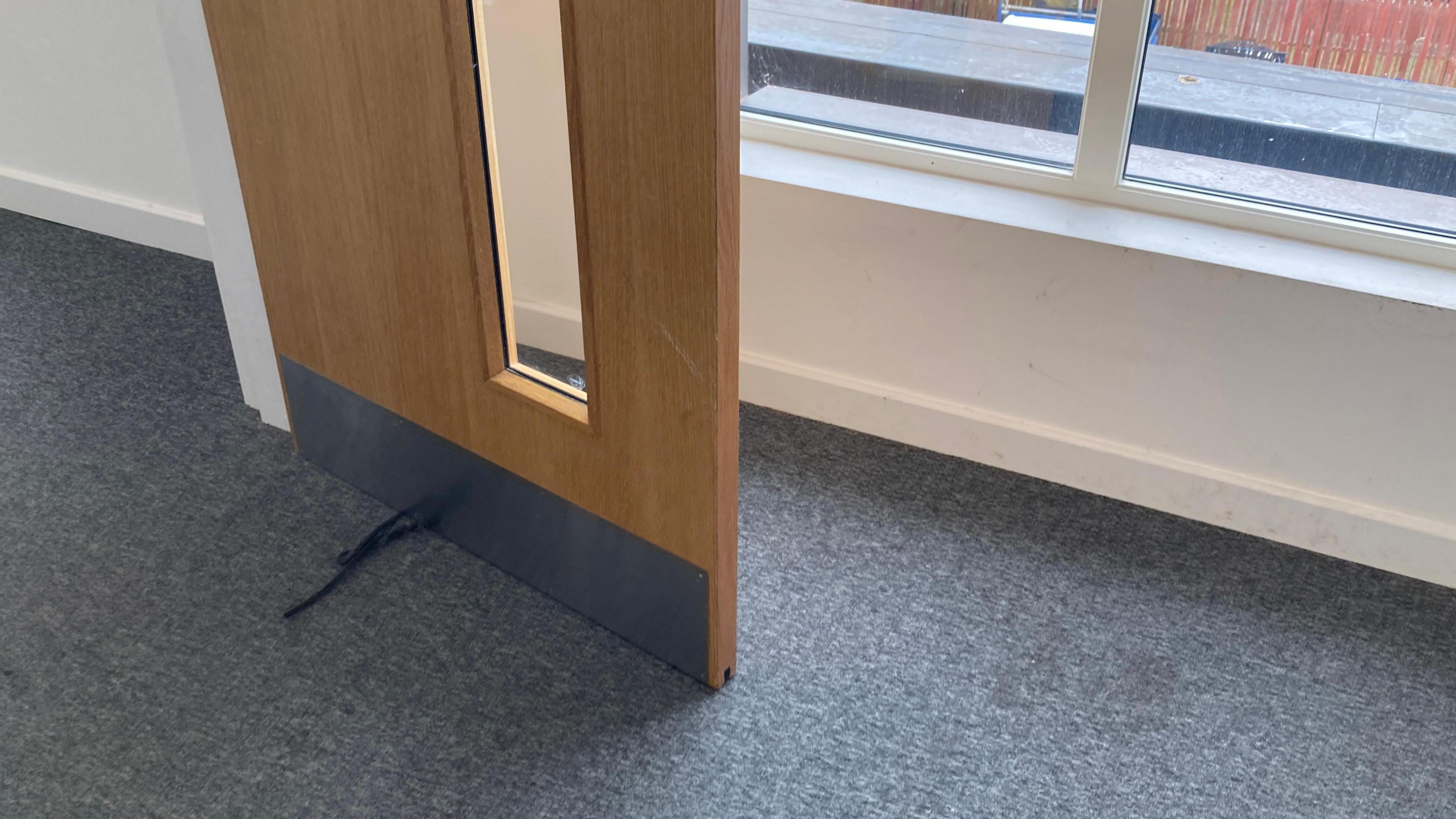 A view of the open fire door, with the strip that is meant to keep the door closed and sealed falling off at the bottom
