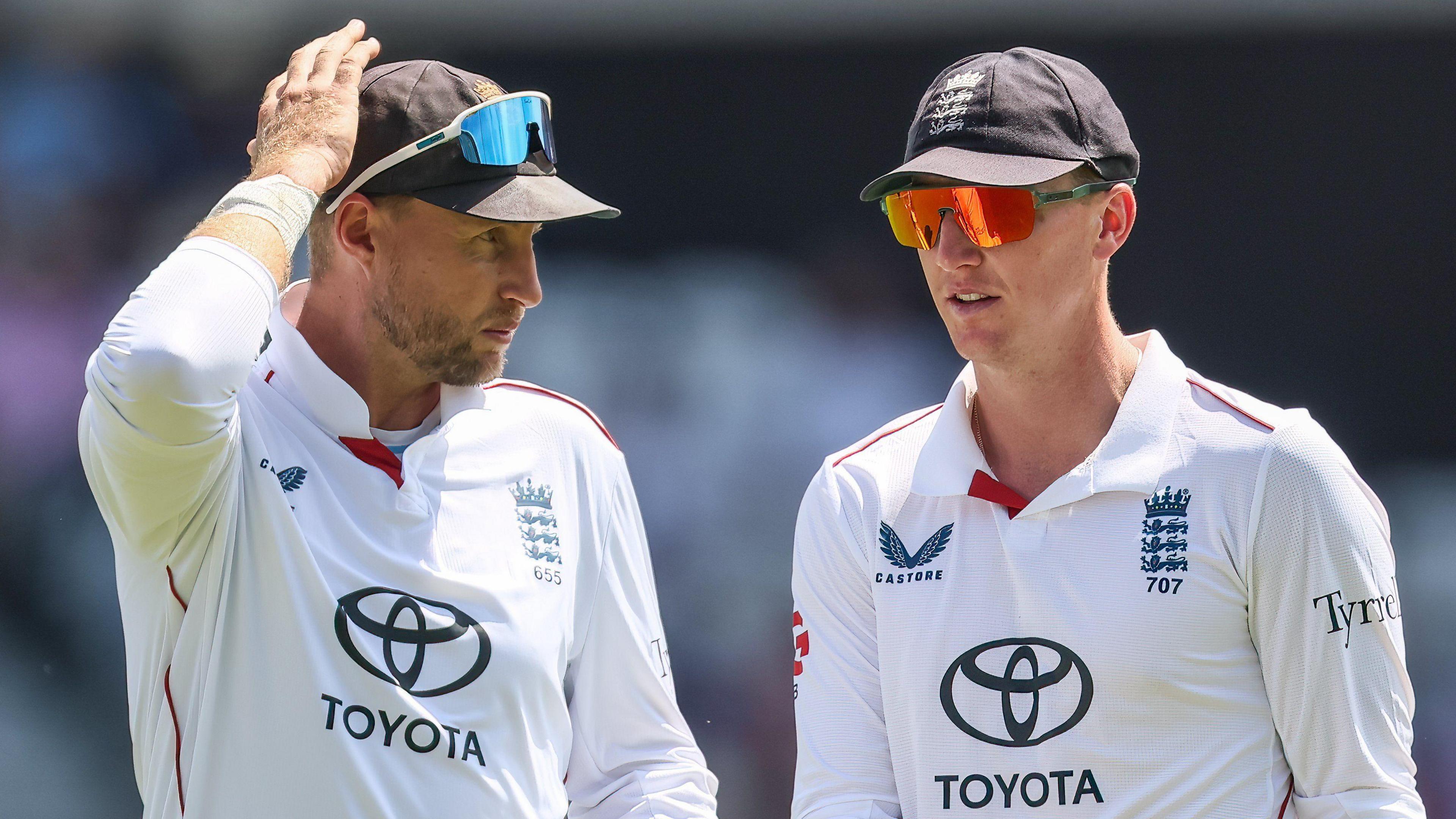 England players Joe Root (left) and Harry Brook (right) confer during a Test match