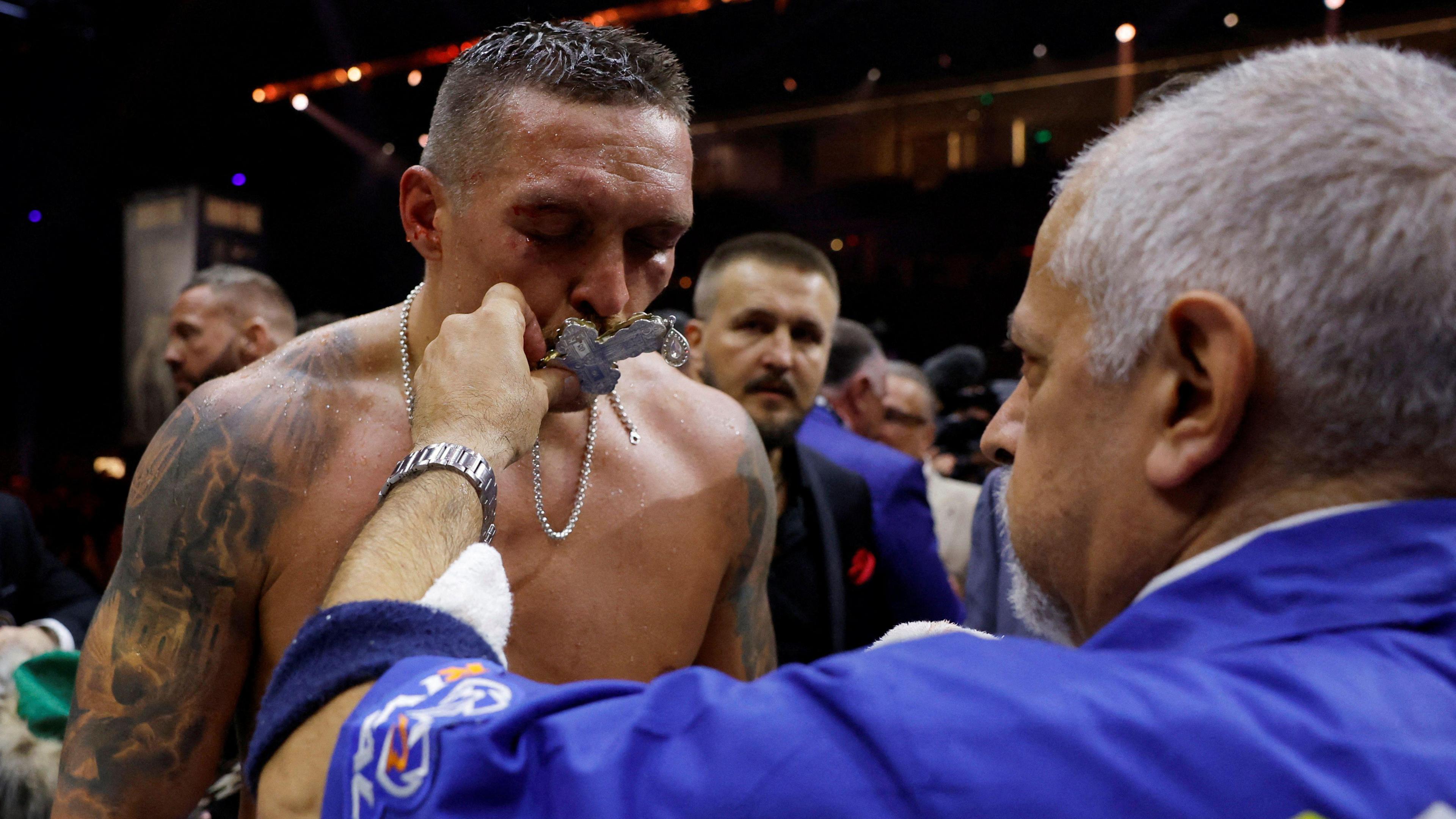 Oleksandr Usyk kisses the cross