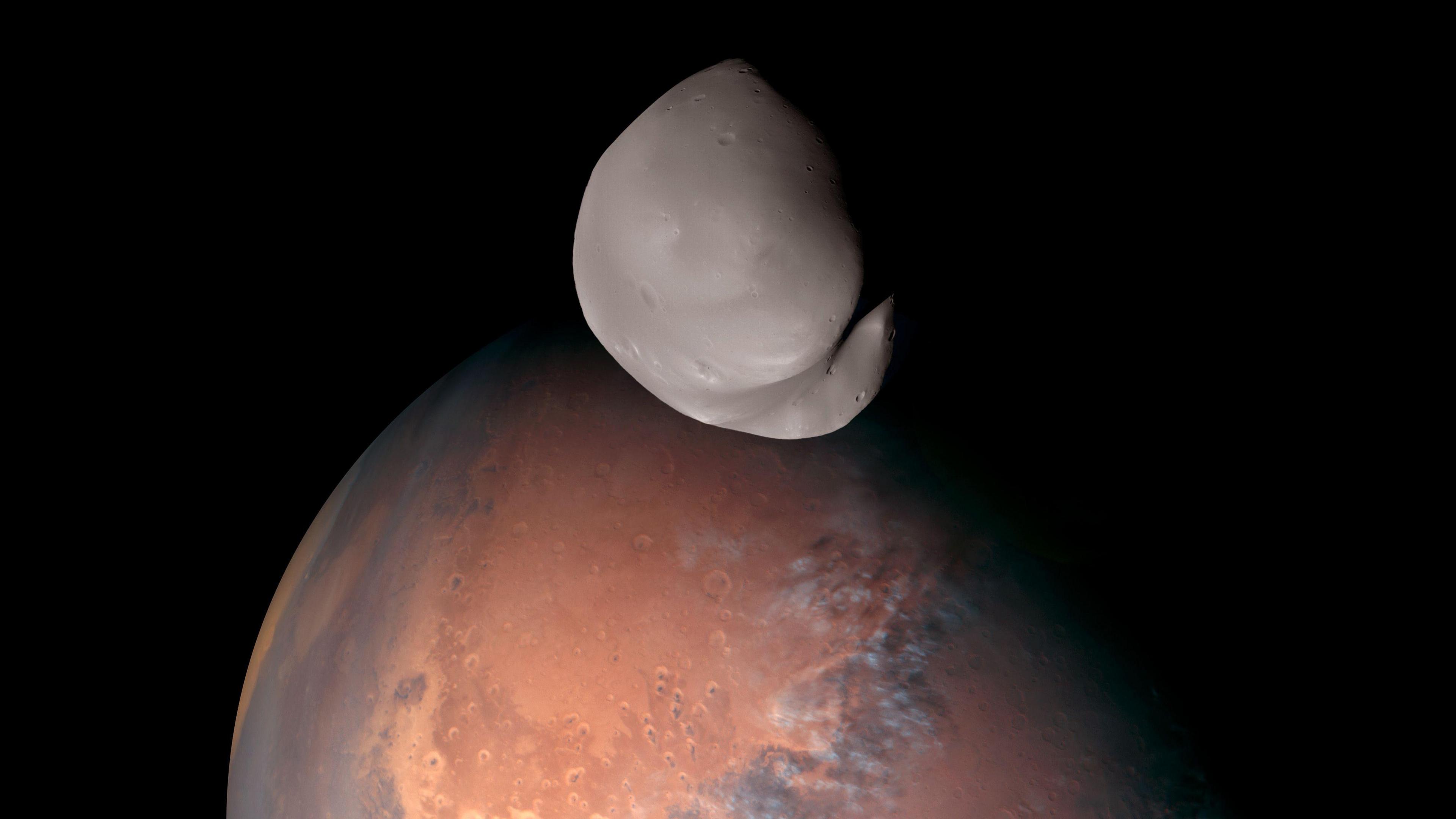 A lumpy moon, Deimos, orbits the red planet Mars