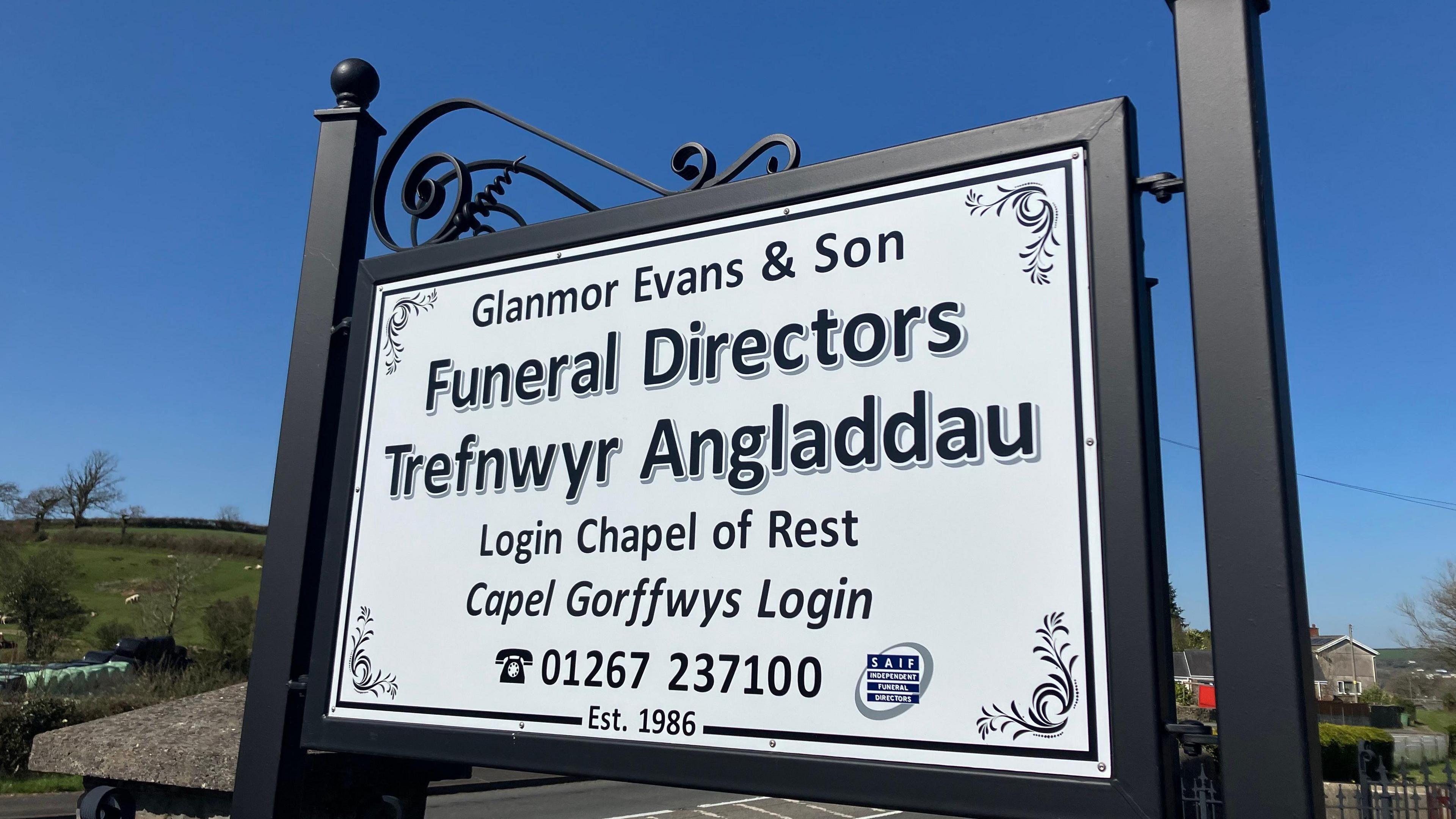 A funeral director's sign in Welsh and English, reading Glanmor Evans & Son