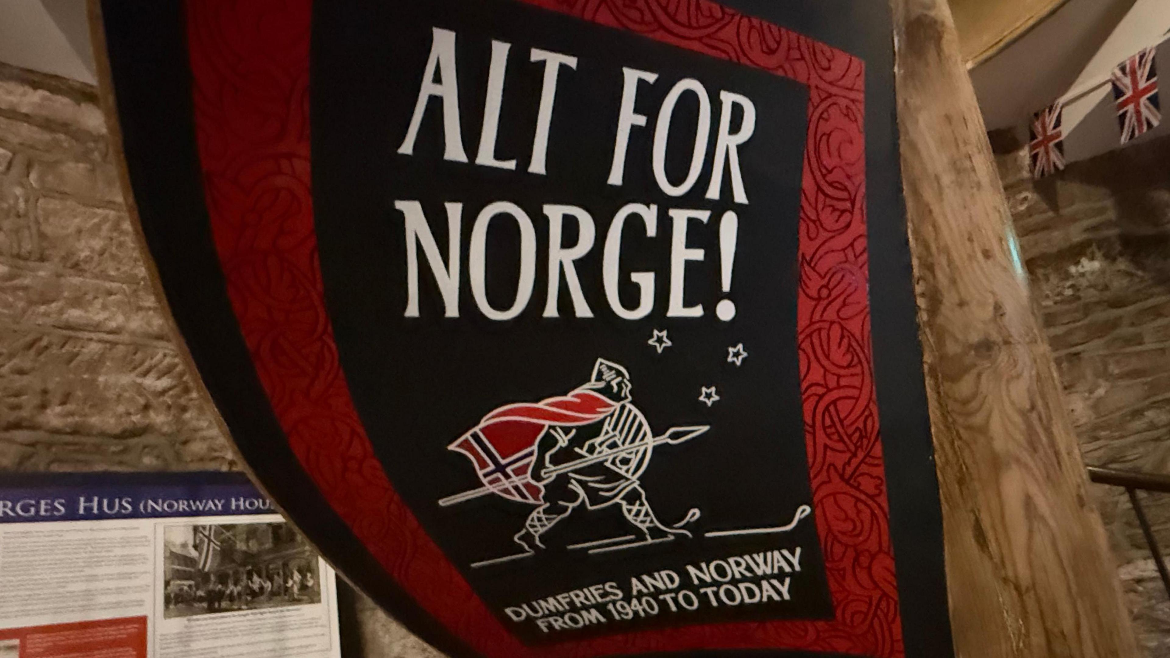 A giant banner with a man on skis with a Norwegian flag on his back and the heading Alt for Norge - All for Norway. Dumfries and Norway from 1940 to today is the sub-heading.