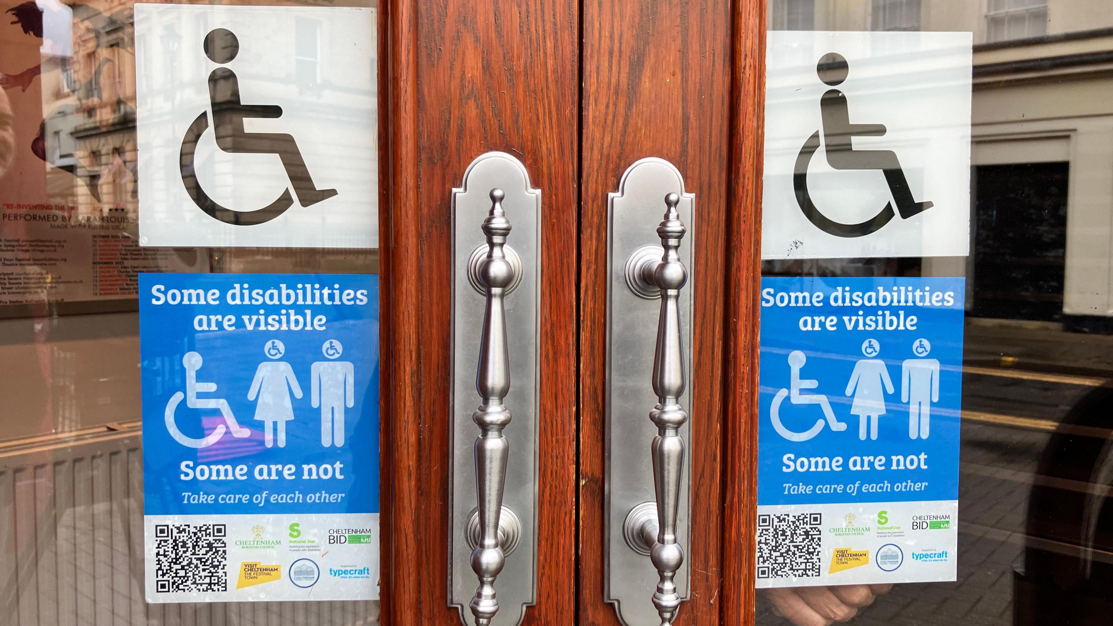 Alternative logo that shows two able bodied people with a third person in a wheelchair and the wording, “Some disabilities are visible. Some are not. Take care of each other”.