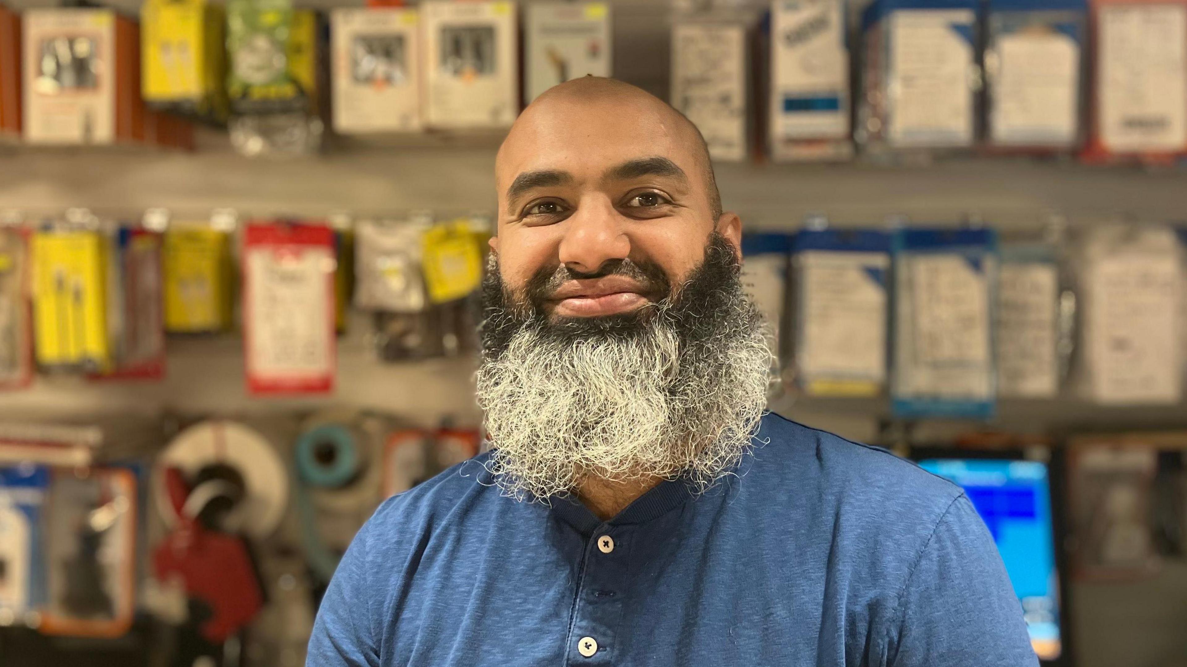 Abdul Ghafoor, an Asian man with a black and grey beard. He is smiling in the photo and wearing a blue t-shirt.