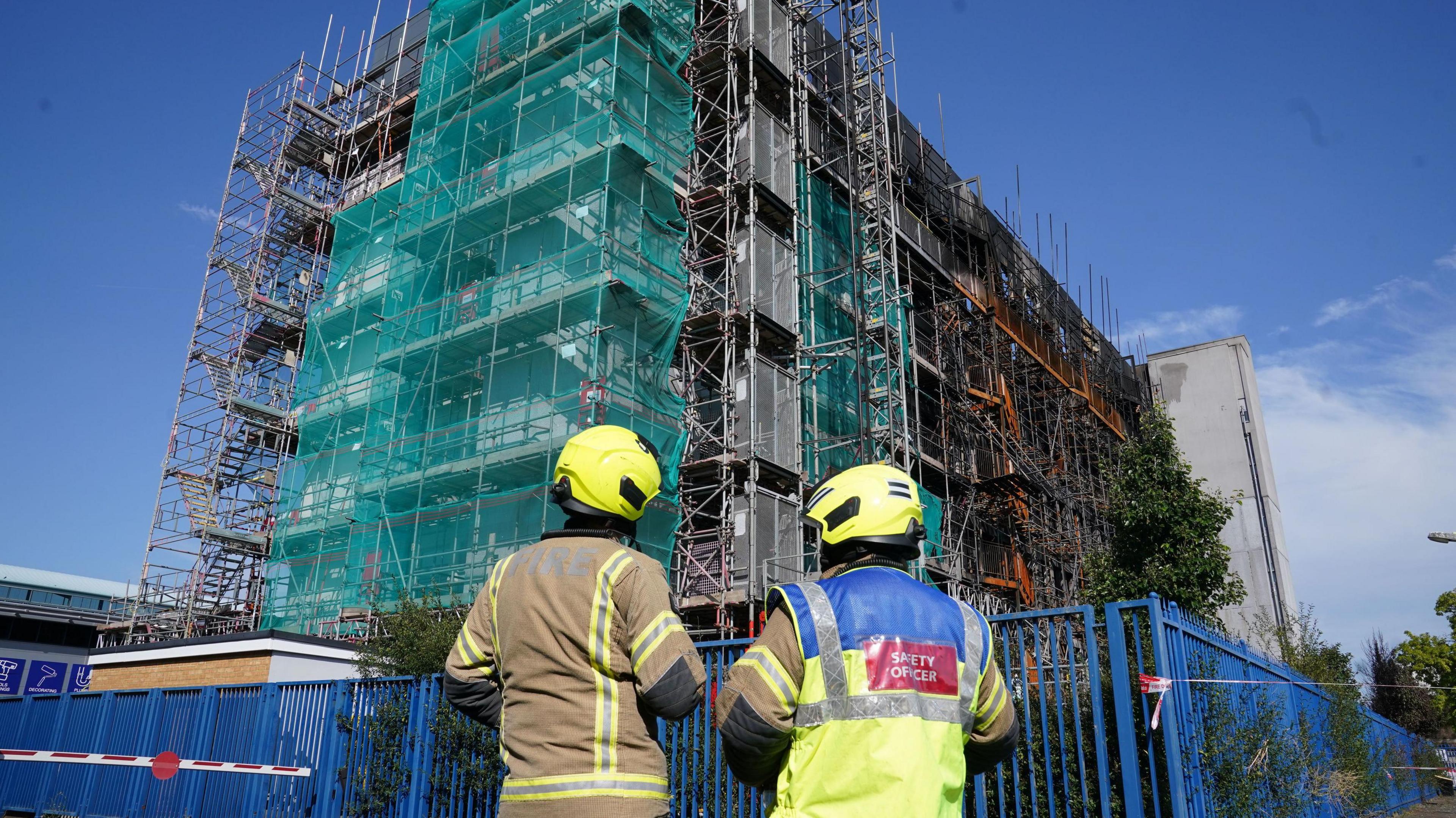 A firefighter and a fire safety officer looking at the scene in Dagenham