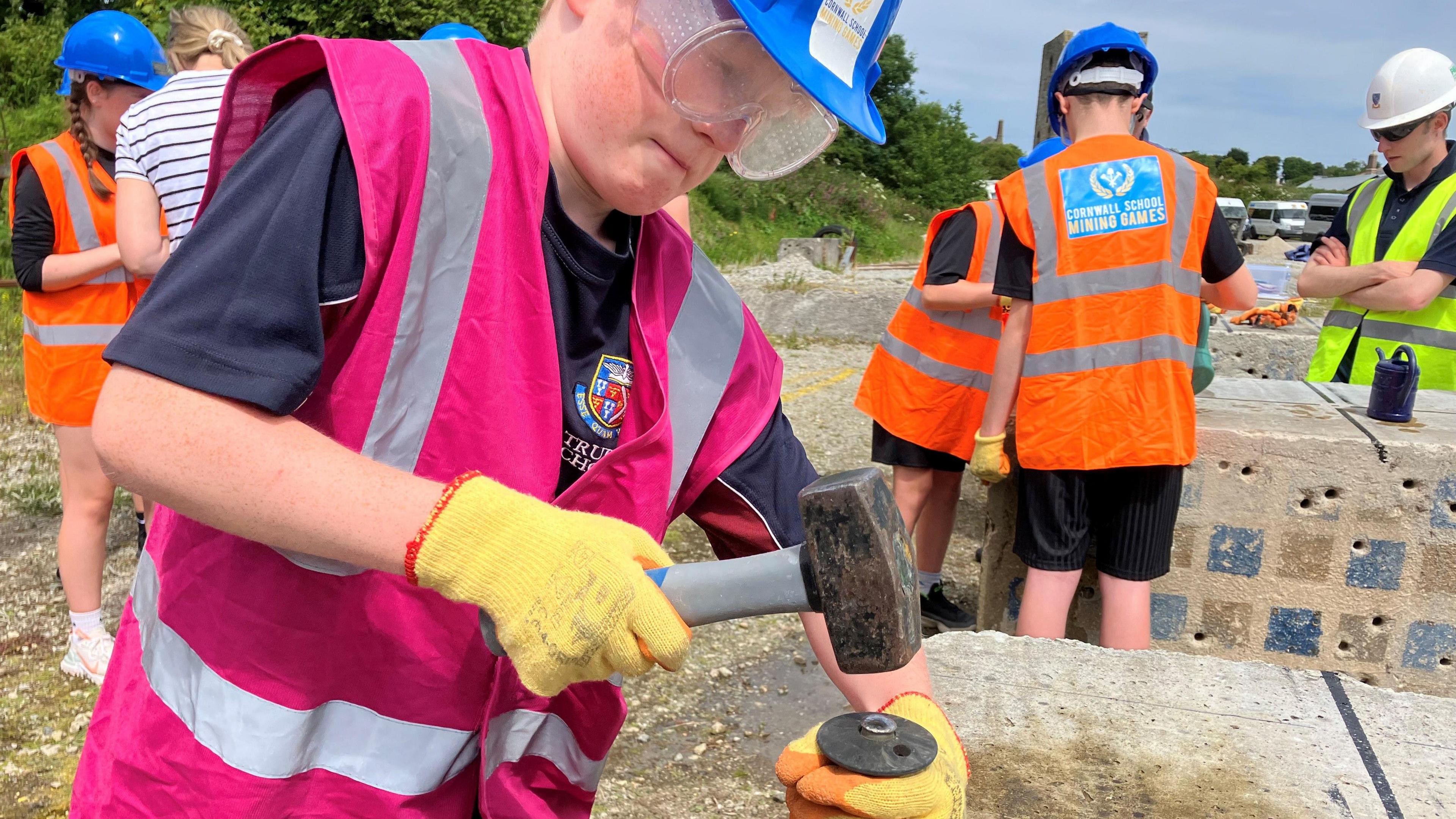 Child hammering a pin into rock