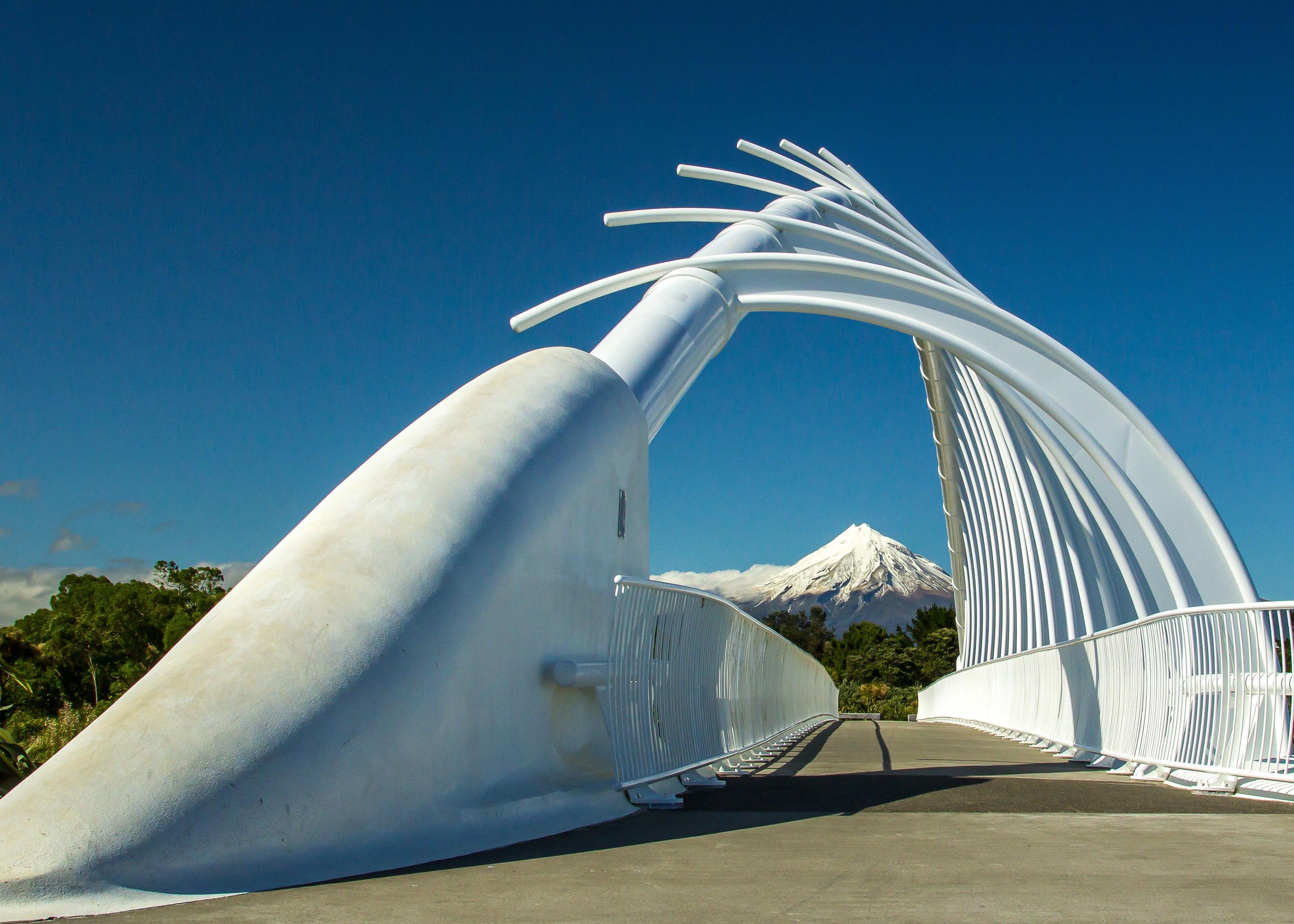 The white arches of Te Rewa Rewa Bridge in New Zealand, with Mt Taranaki in the background