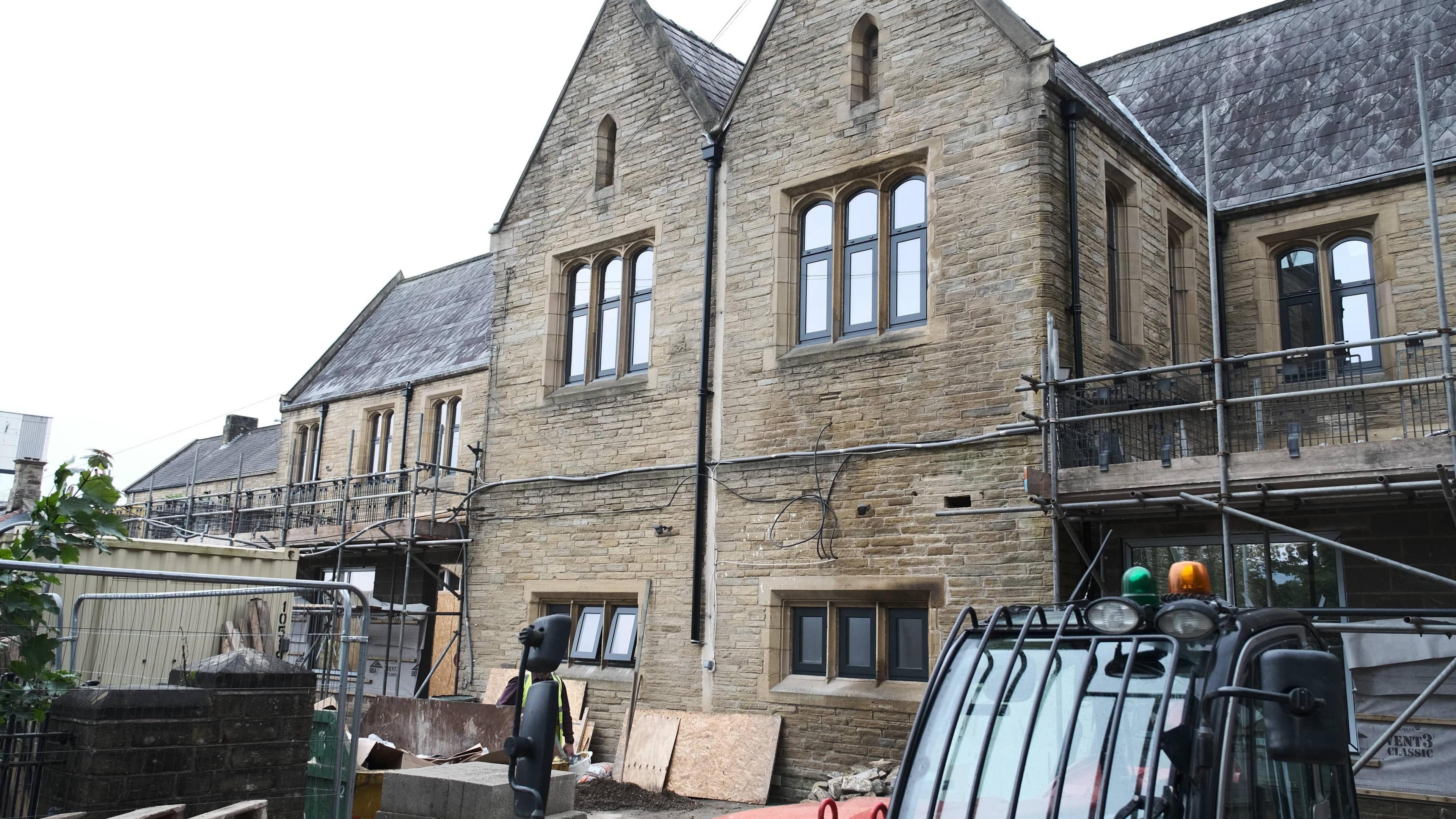 The nearly refurbished Kirkgate Centre. Pictured is a stone building with two sets of oblong windows and the remnants of a construction site at the base of the property.