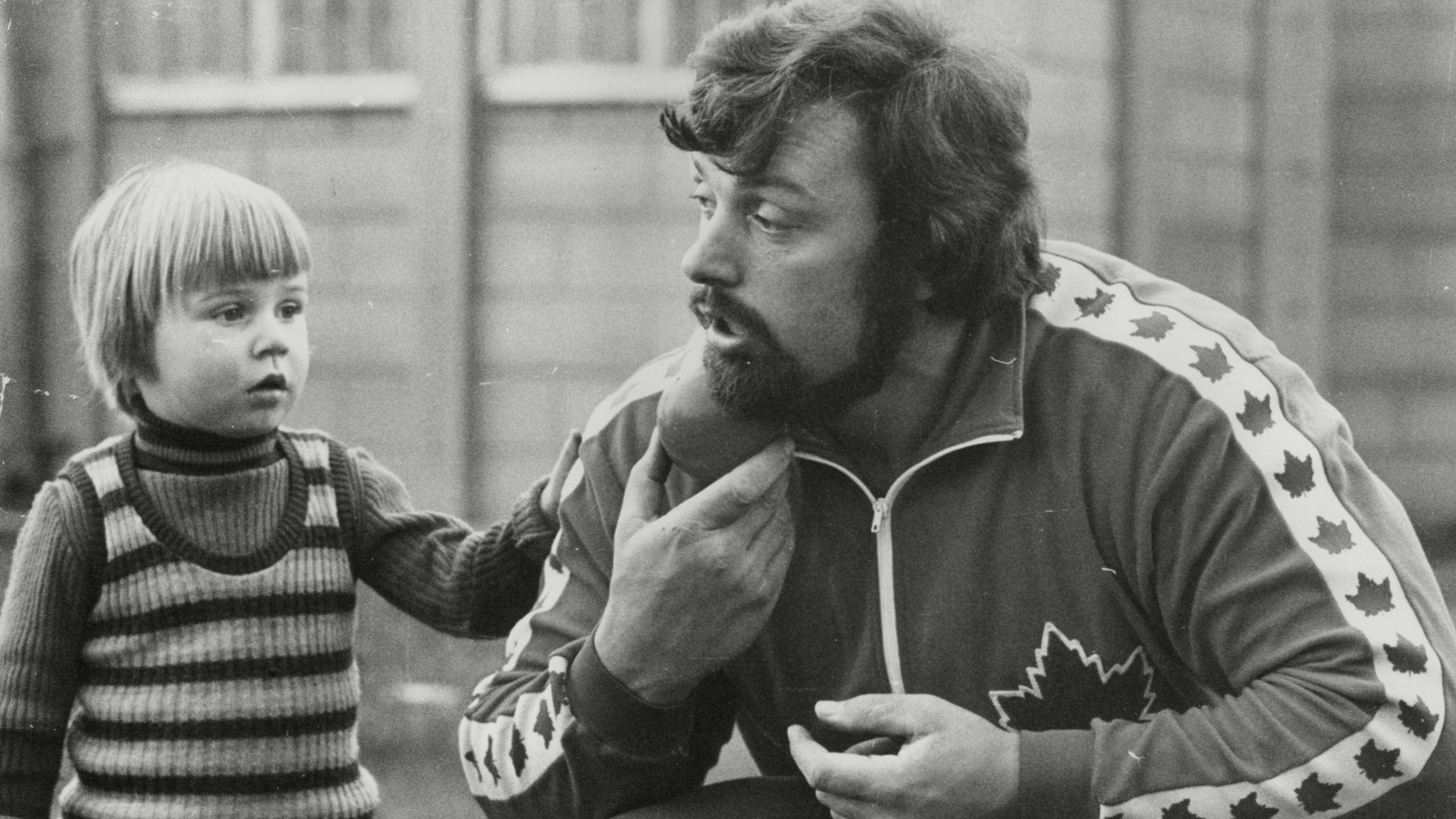 Geoff Capes in conversation with his son Lewis, a young boy at the time of the photo. 