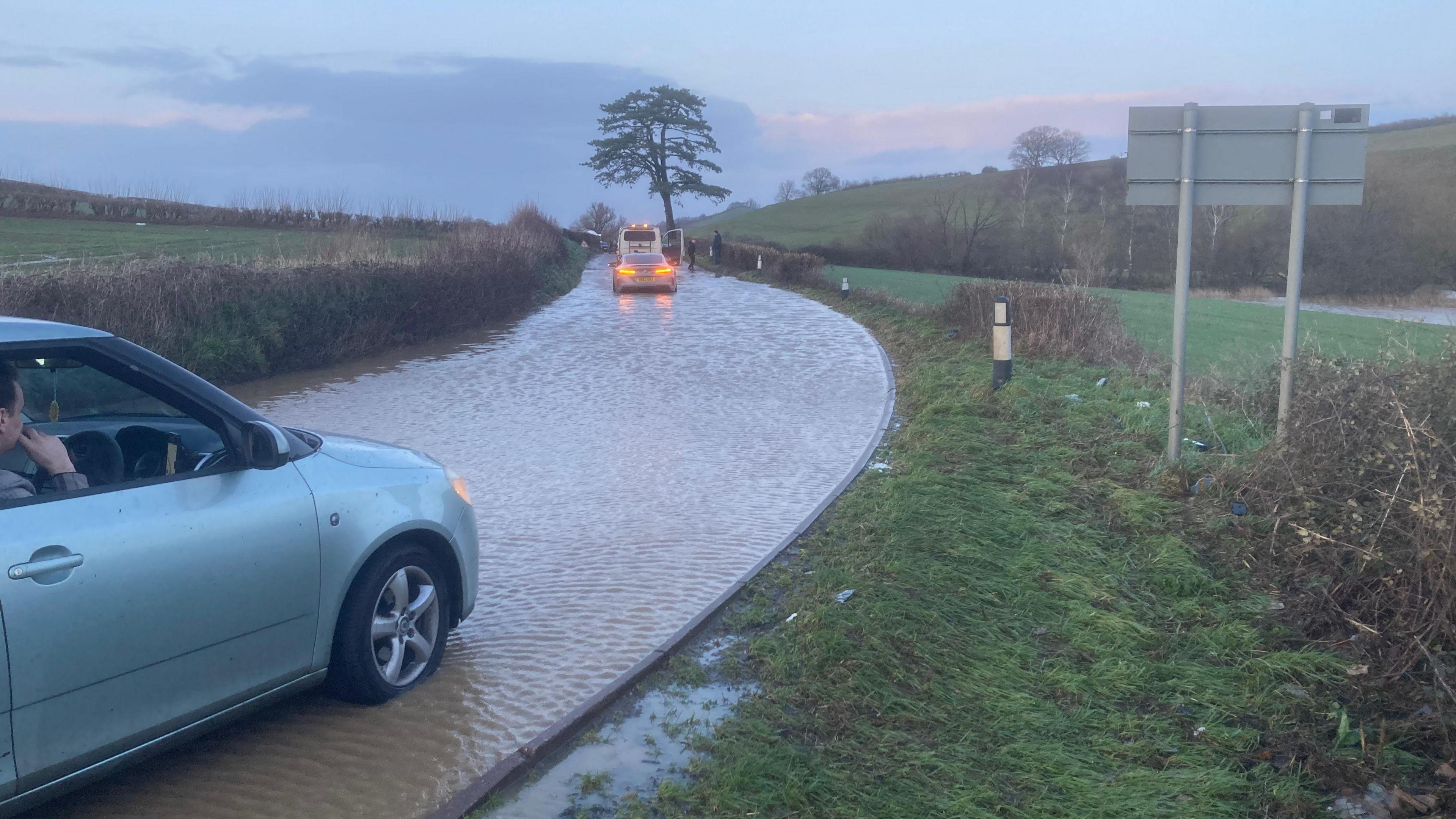 A car stuck on in flood water on a completely flooded lane