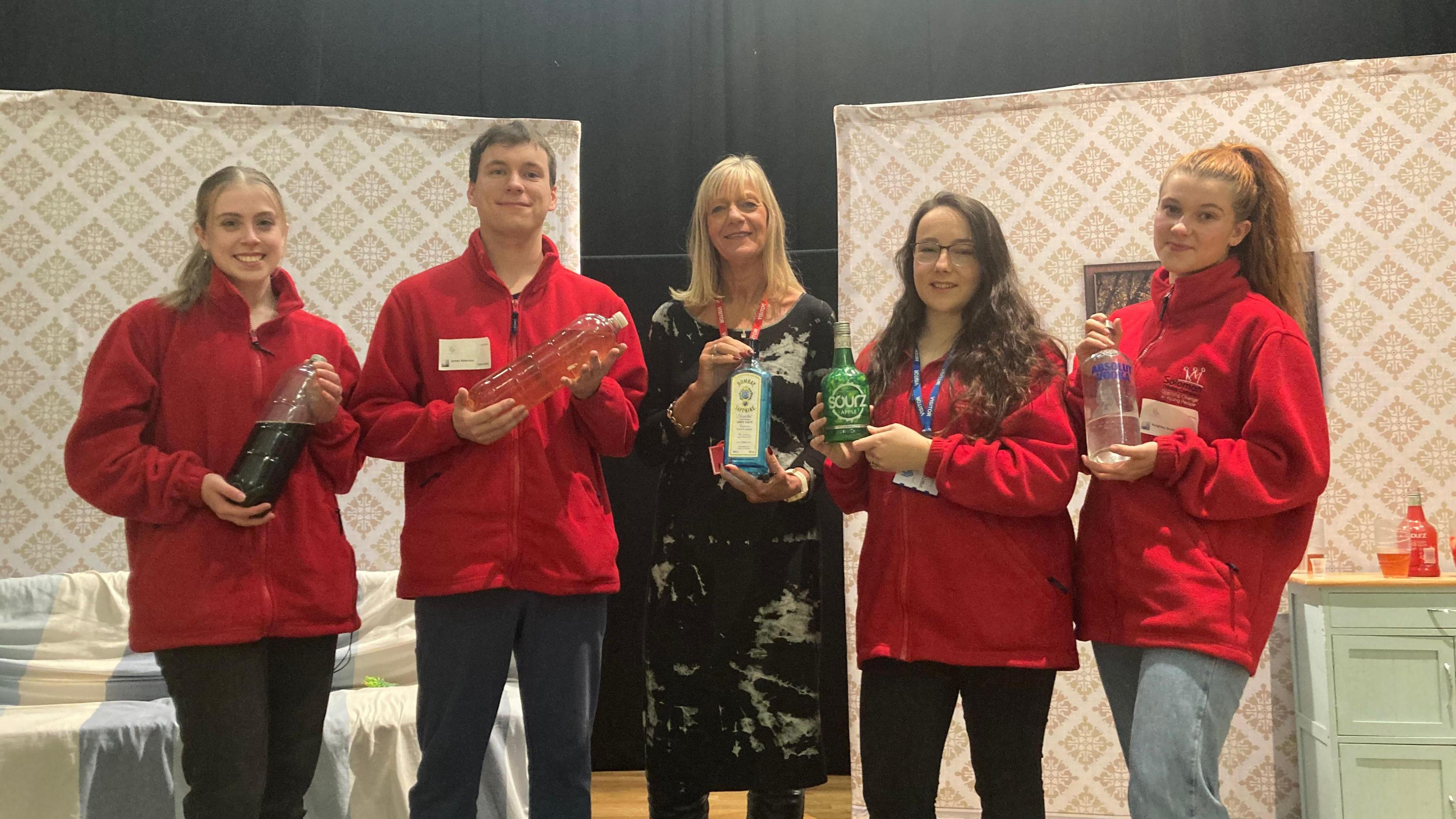 Solomon Theatre Group and Andrea Nightingale holding alcohol props