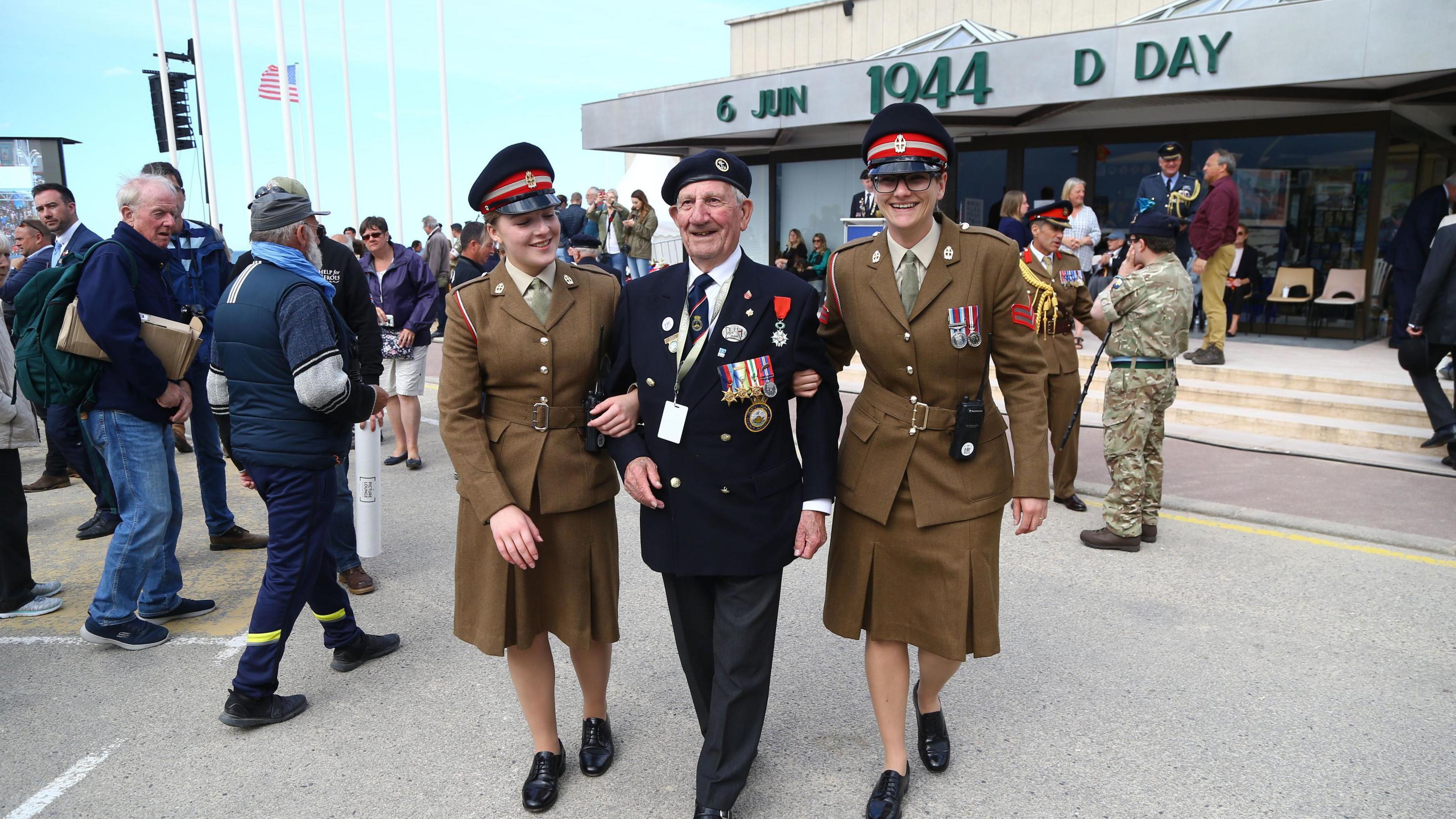 George Chandler leaving following a service in Arromanches, France, commemorating the 75th anniversary of the D-Day landings, supported by two members of the Women's Royal Army Corp.