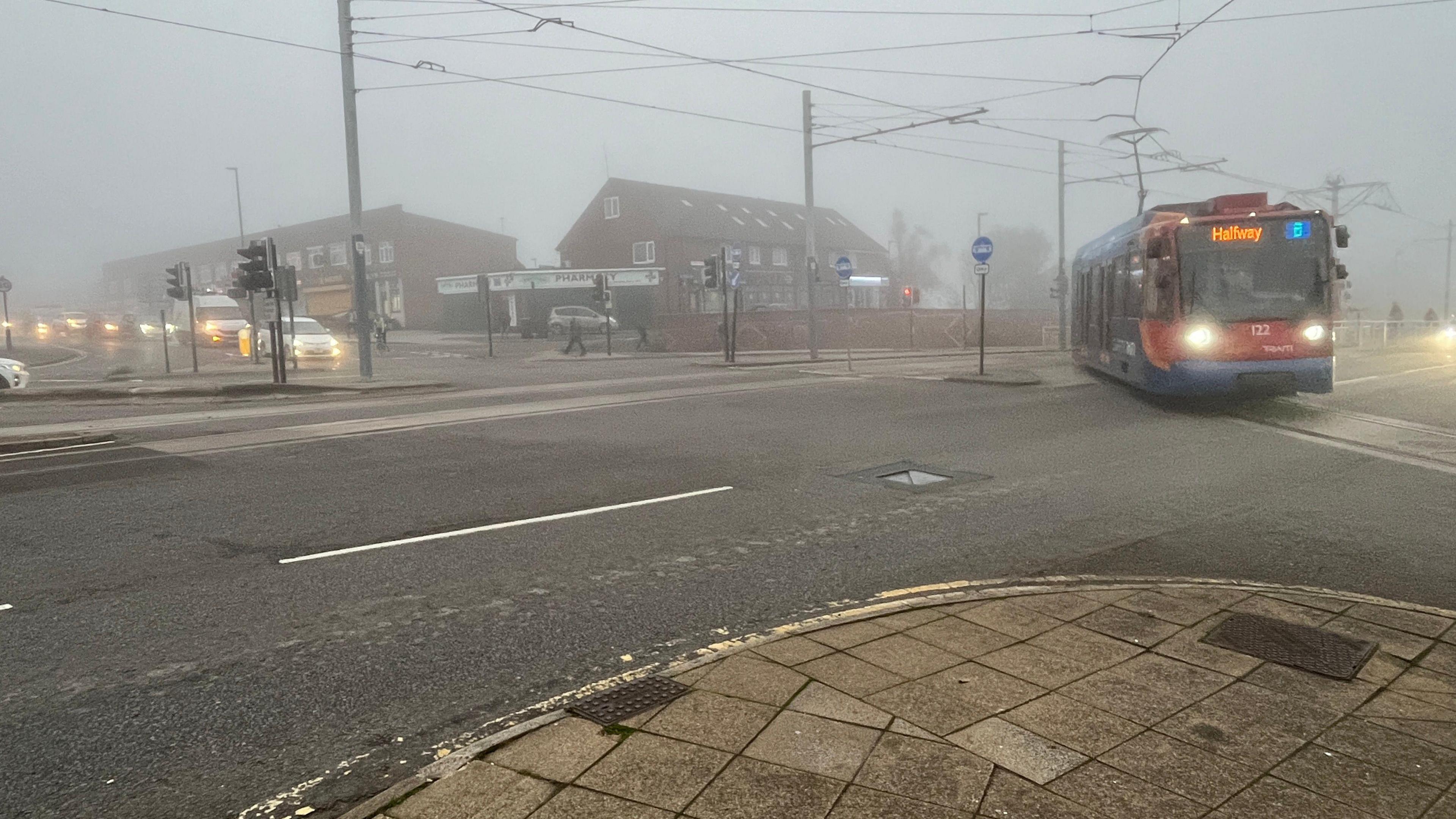 A tram turns onto Gleadless Road in Sheffield in foggy conditions