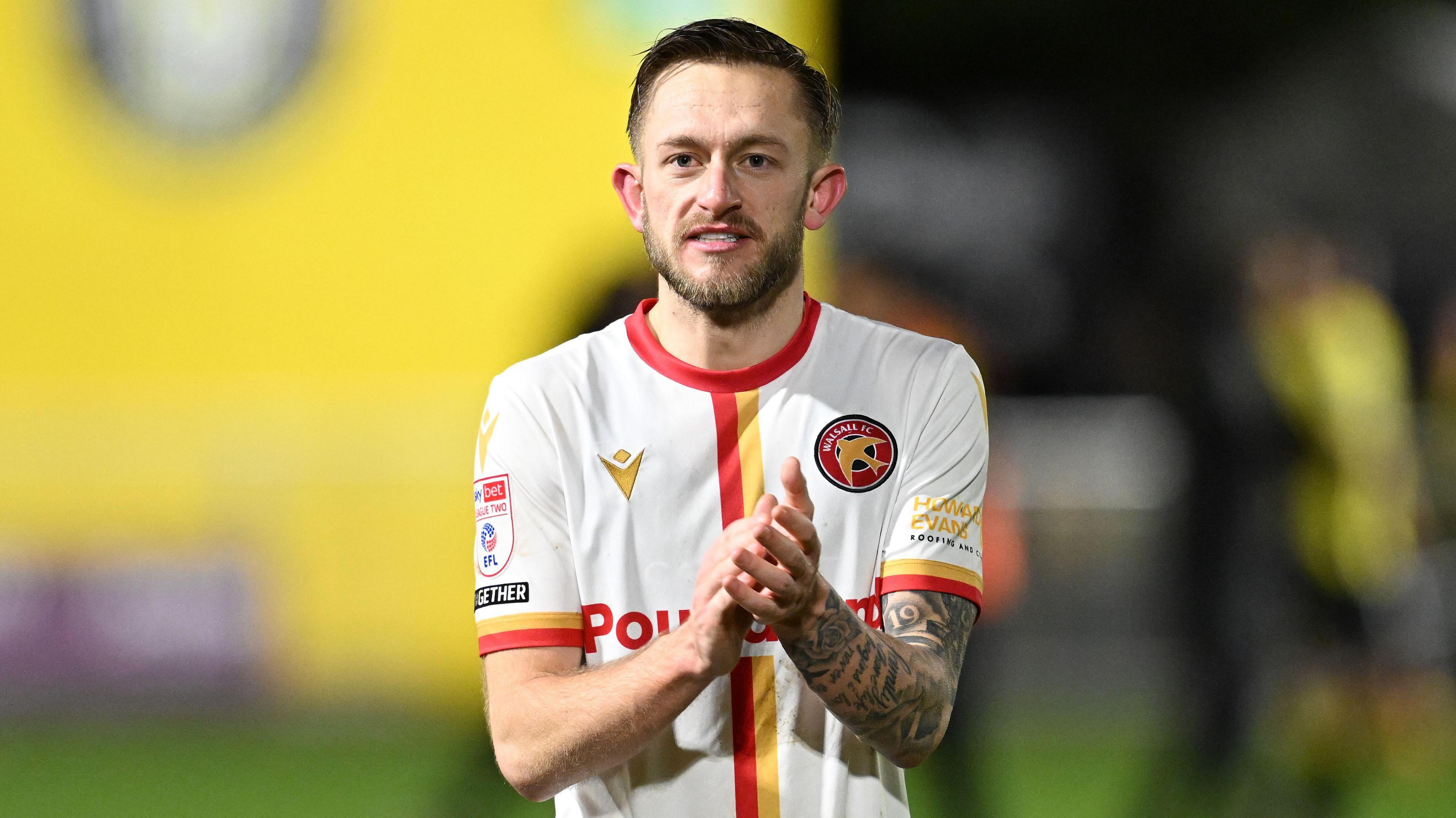 Walsall player Charlie Lakin claps the fans at the end of a game