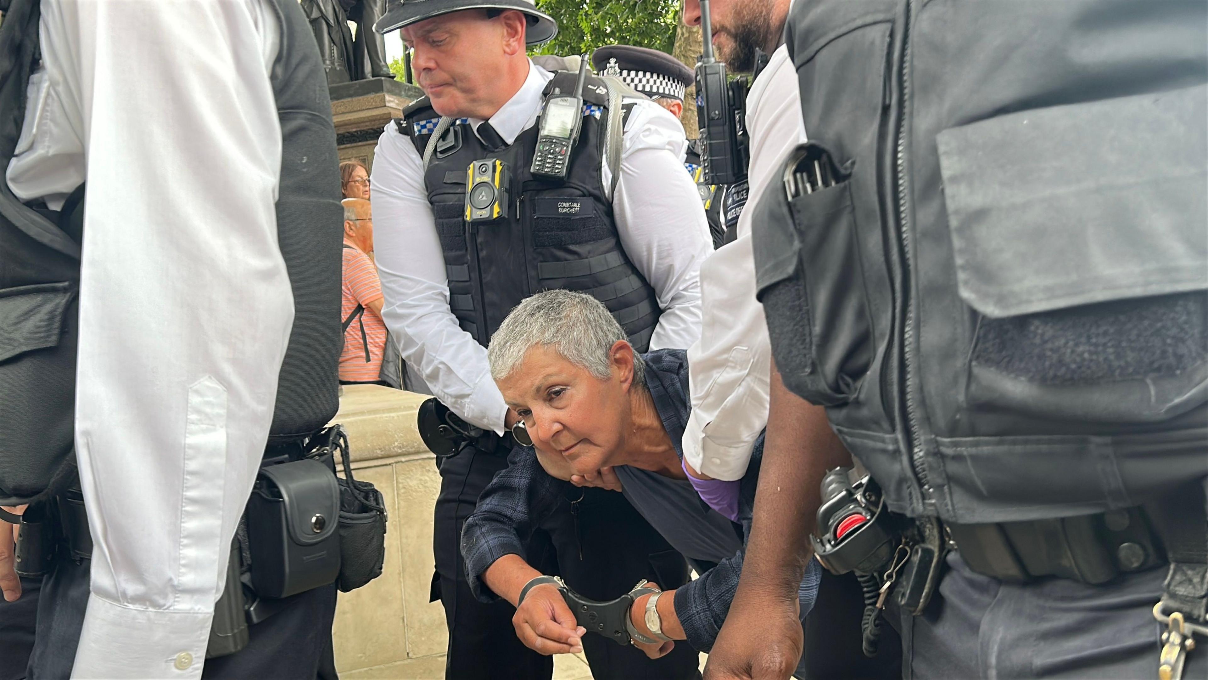 A woman being handcuffed and dragged away by police at protests in support of Palestine Action