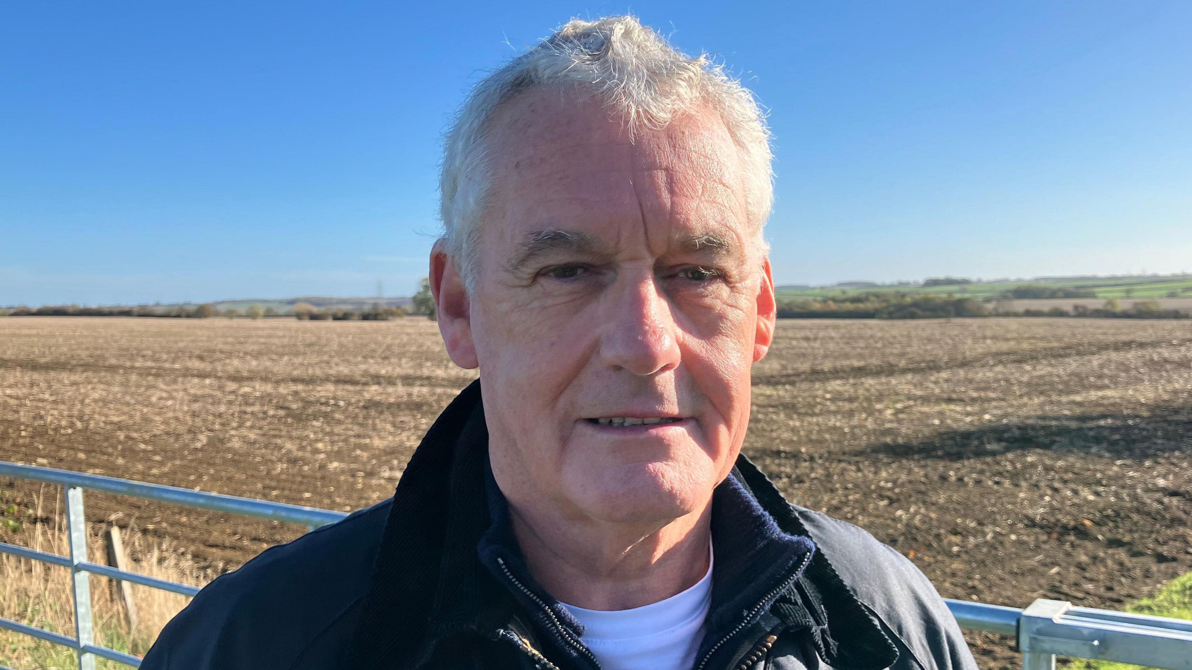 Kevin Shapland stands against the backdrop of land to be developed for warehousing.