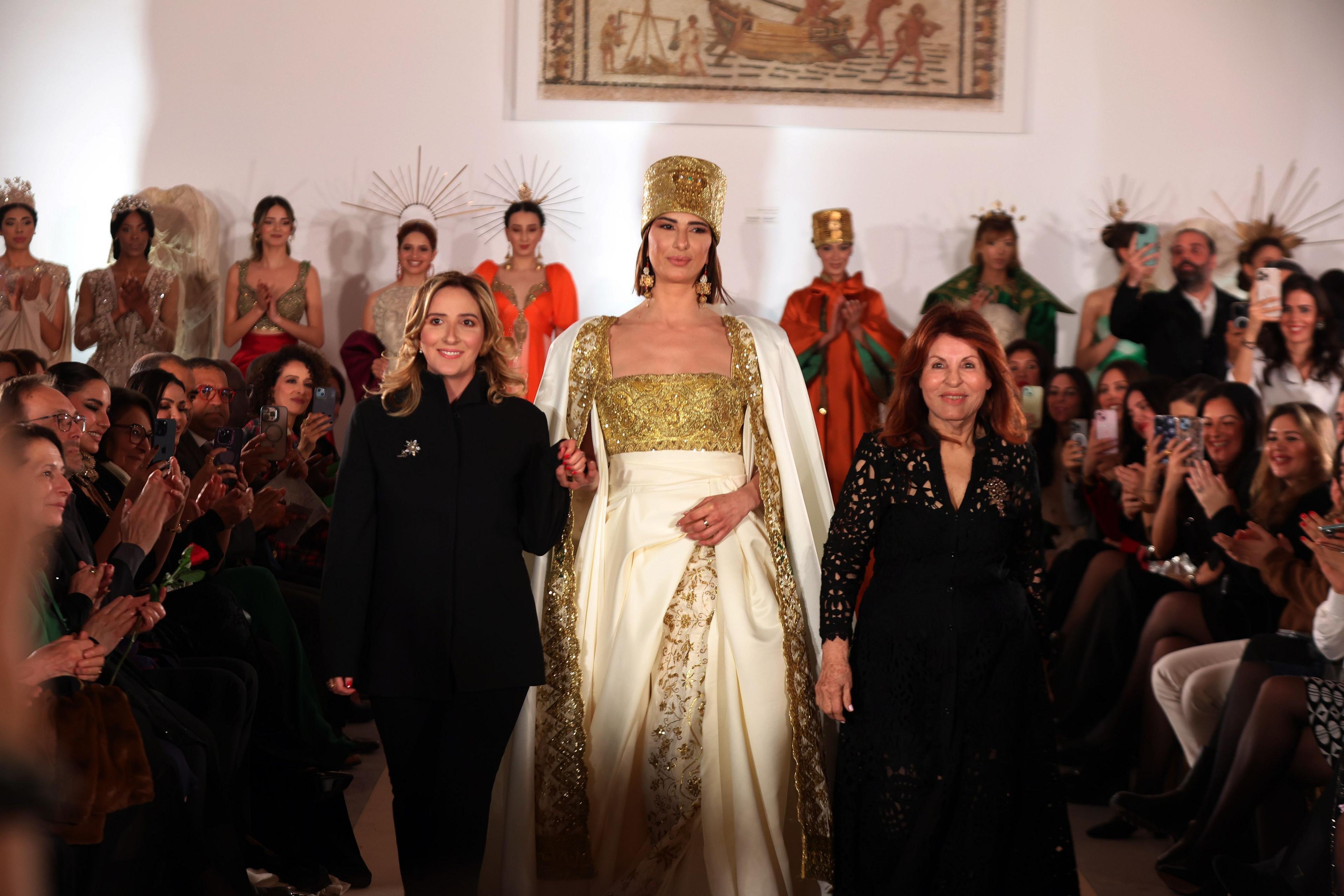 Tunisian designer Fatma Ben Abdellah (R) with her daughter Nour (L), who is also a designer, appear on stage during a fashion show.