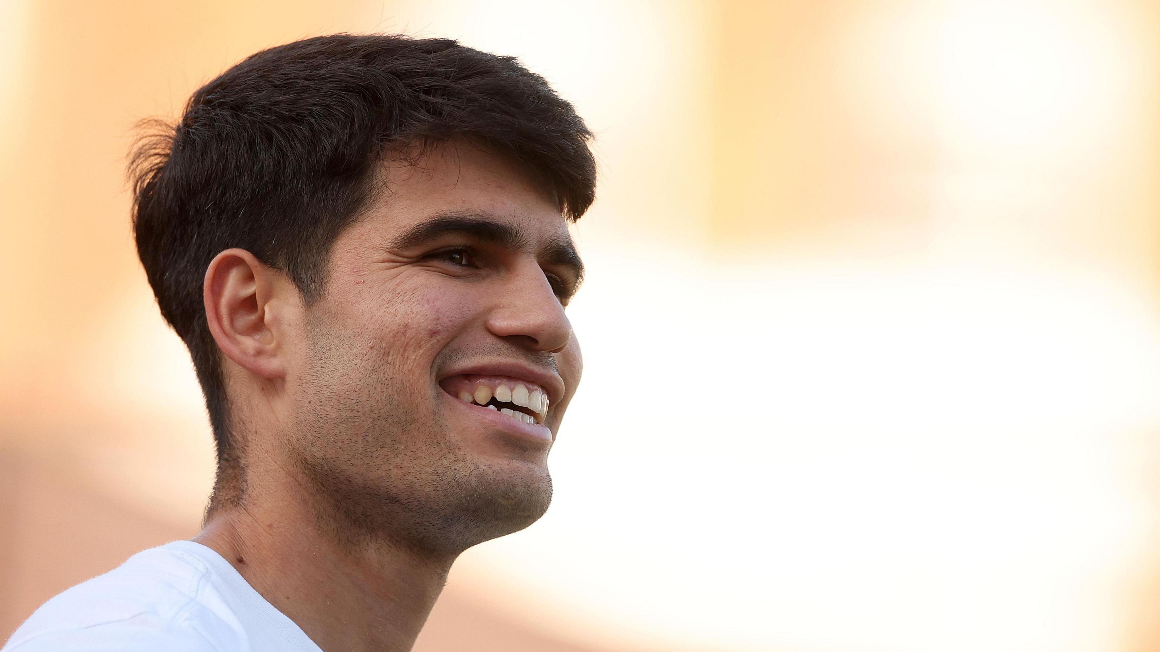 Carlos Alcaraz smiles during practice at Queen's