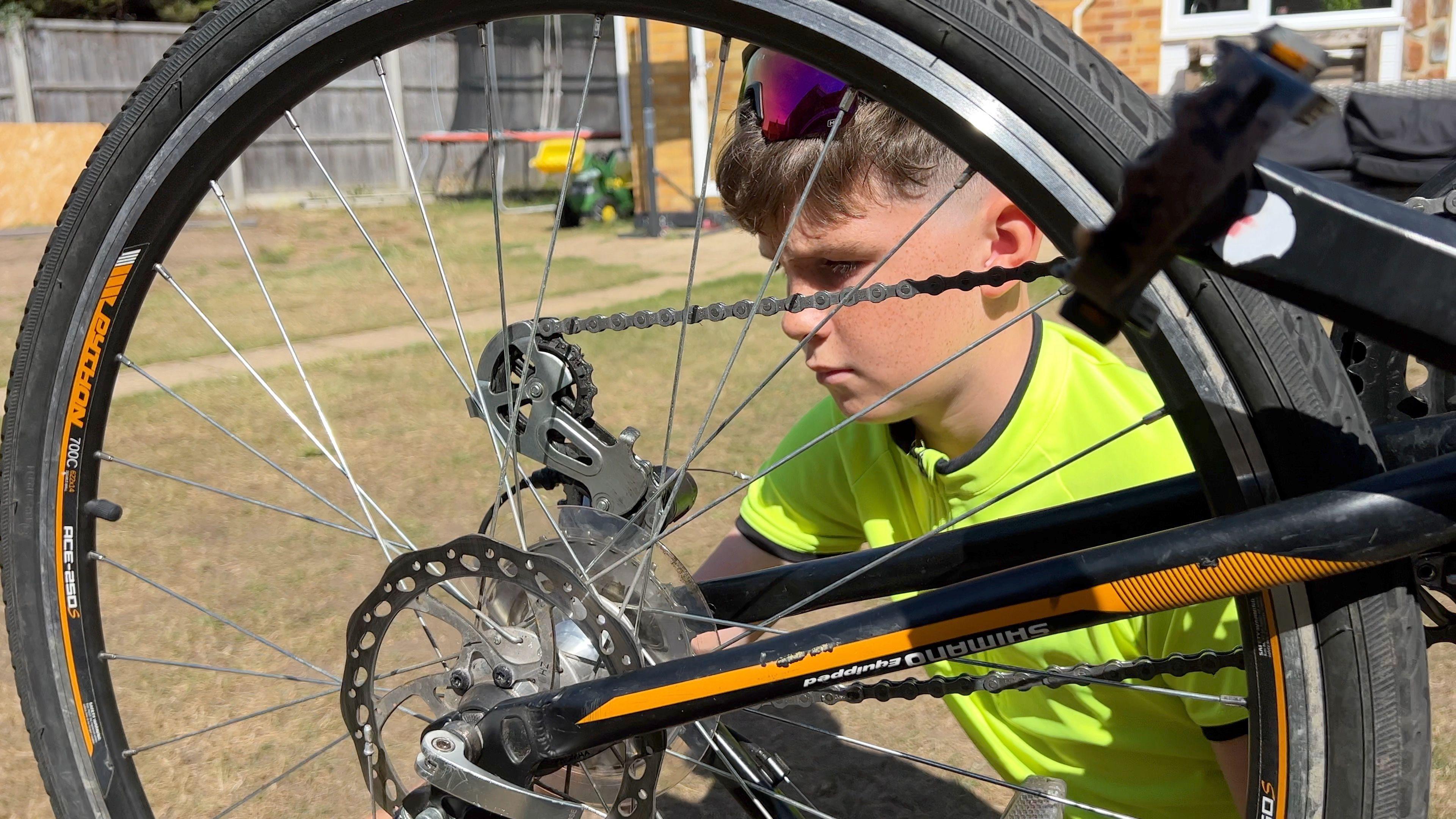 Dexter checks the gears on his cycle.