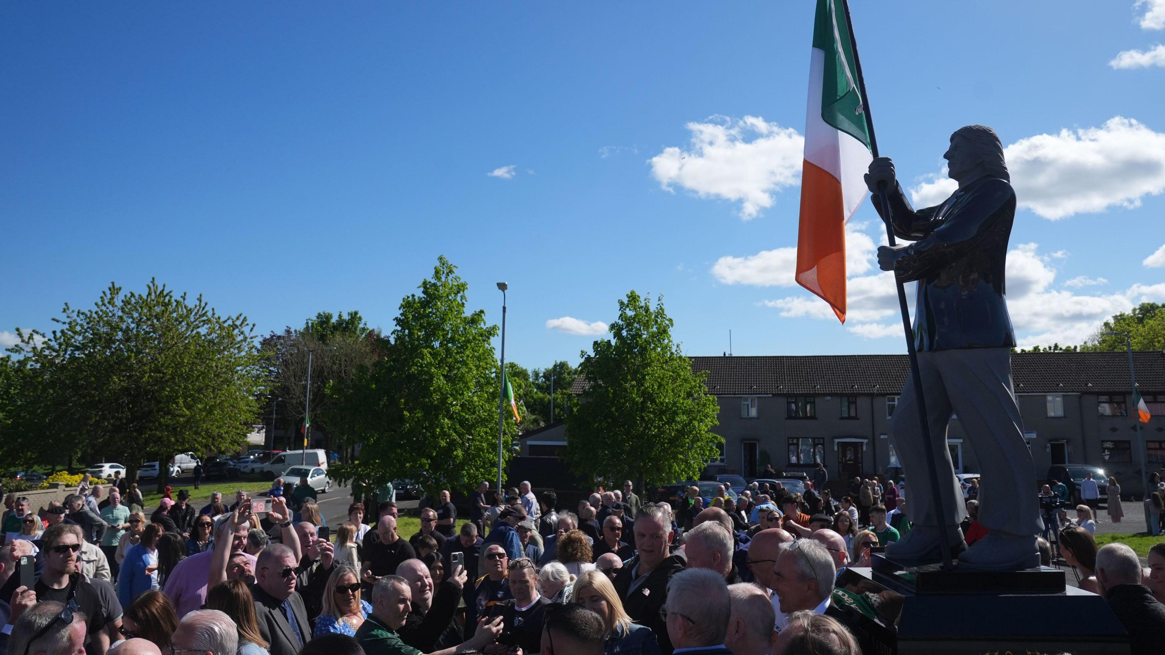 A crowd gathered in west Belfast in May at the unveiling of a statue on a plinth of Bobby Sands, which depicts the IRA hunger striker holding an Irish tricolour flag