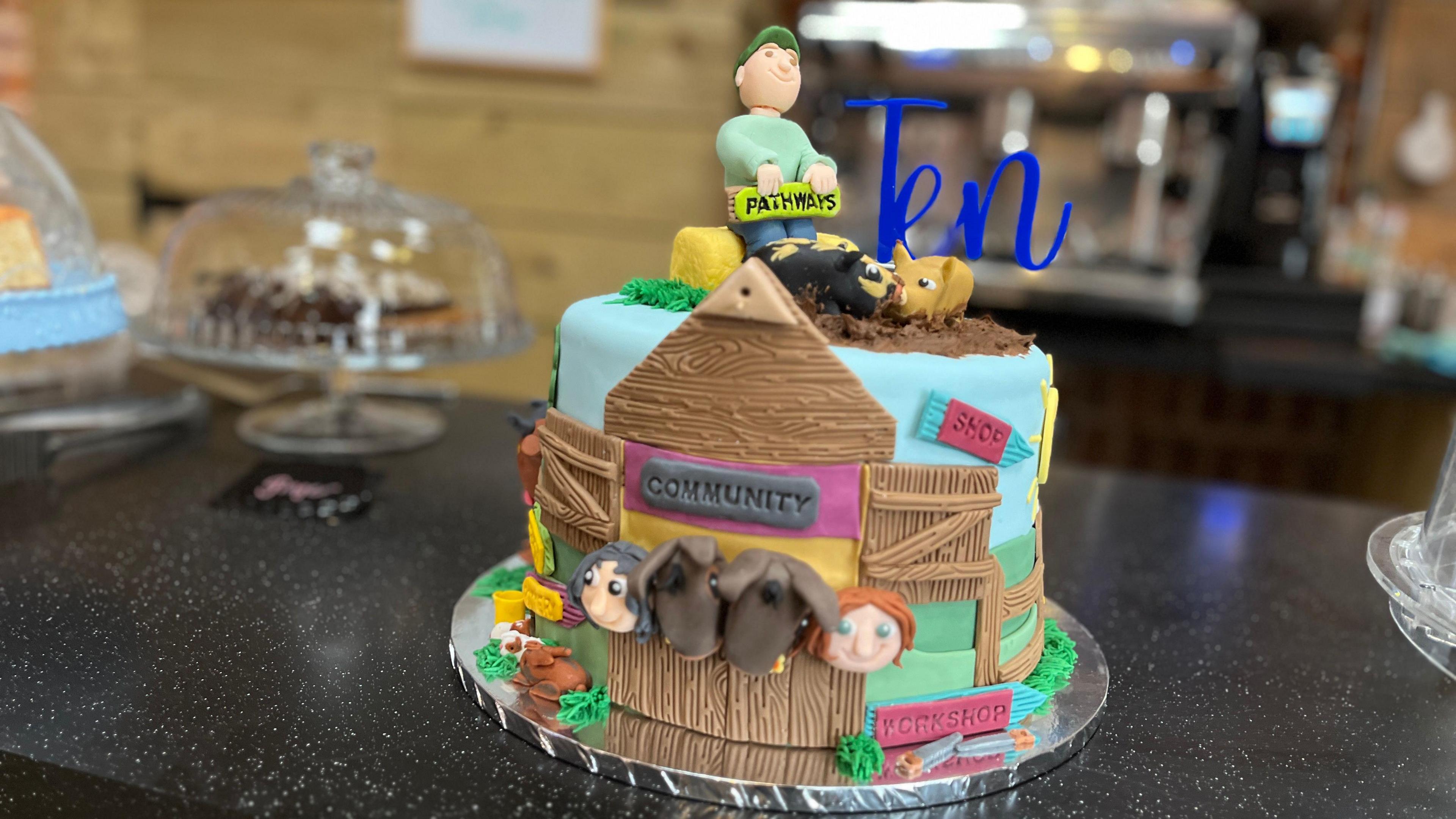 A colourful cake, with icing farm animals.